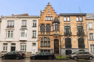 ETTERBEEK – Tussen de Chasse en de Avenue de la Couronne, in een van de veiligste straten van Etterbeek dankzij de nabijheid van de kazerne en het gemeentehuis van Etterbeek, staat een huis dat in 1912 door architect Augustin Goovaerts in neogotische stijl werd gebouwd. Dit huis met een bewoonbare oppervlakte van ±435 m² wordt gekenmerkt door zijn architectuur en zijn halve toren die vanaf de straatkant zichtbaar is.<br /><br /><span>Bovenste begane grond:</span><br /><br />3 aaneengesloten woonruimtes van respectievelijk ± 19 m², 20 m² en de bibliotheek over 2 verdiepingen van elk ± 25,5 m², elk met hun historische kenmerken zoals originele wandtapijten en antieke schouwen; de bibliotheek heeft ook toegang tot 2 kantoren en de tuin.<br /><br /><span>Benedenverdieping:</span><br /><br />2 ruime multifunctionele kamers van ± 17 m² en ± 15 m² en achterin een grote ingerichte keuken met toegang tot de tuin.<br /><br /><span>1e verdieping: </span><br />
<ul>
<li>2 slaapkamers van ± 19 m² en ± 21 m²</li>
<li>Toilet</li>
<li>Kleedruimte van ± 7,5 m²</li>
<li>Badkamer van ± 9 m²</li>
</ul>
<span>2e verdieping:</span><br />
<ul>
<li>Een slaapkamer van ±16 m²</li>
<li>De ouderslaapkamer van ±18 m² met eigen doucheruimte, wastafel en een ingebouwde kleedkamer</li>
<li>Een gemeenschappelijke badkamer met toilet van ±10 m²</li>
<li>Een kleedruimte van ±9,5 m²</li>
</ul>
Op de bovenste verdieping bevindt zich een inrichtbare zolder van ± 34 m²<br />Verschillende ruimtes onder de trap bieden extra opbergruimte. Er zijn ook kelders, waaronder een wijnkelder. Het huis is voorzien van een intercom en glasvezel.