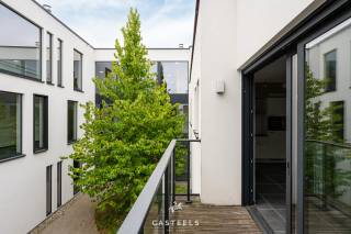 <br />Een nieuwbouwappartement geschikt voor jong en oud die rustig willen wonen in de Vlaamse Ardennen.<br /><br />Comfortabel en energiezuinig wonen in Kluisbergen. Dit nieuwbouwappartement heeft een gunstige ligging in het gebouw op de 1e verdieping. Hierdoor geniet u van extra lichtinval en een binnenpatio. Het appartement is reeds volledig afgewerkt; enkel de schilderwerken moeten nog worden uitgevoerd.<br /><br />De troeven van dit appartement:<br />-Unieke ligging: Met veel natuurlijke lichtinval en zicht op de binnenpatio.<br />-Energiezuinig &amp; toekomstbestendig: Dankzij de recentste isolatienormen en moderne bouwtechnieken geniet u van een uiterst lage energiefactuur en een aangenaam, constant binnenklimaat.<br />-Optimaal comfort: U geniet van het comfort van wonen op de 1e verdieping met een eigen, onderhoudsvriendelijk terras om in alle rust buiten te zitten.<br />-Volledig afgewerkt (incl. schilderwerken naar eigen smaak): Het appartement is helemaal instapklaar op de schilderwerken na. Deze zijn reeds inbegrepen in de prijs, waardoor u het kleuren- en  afwerkingspalet nog volledig naar eigen wens kunt kiezen.<br /><br />De lichtrijke leefruimte is voorzien van een prachtige tegelvloer en loopt naadloos over in de moderne, volledig geïnstalleerde open keuken. Daarnaast beschikt het appartement over één volwaardige slaapkamer, een berging en een ruime badkamer.<br /><br />Unieke gemeenschappelijke faciliteiten:<br />Naast uw privatieve terras heeft u direct toegang tot de grote, mooi aangelegde gemeenschappelijke tuin met een petanquebaan, een ontmoetingszaal voor bewoners, een infraroodcabine en een ruime, veilige fietsenberging.<br /><br />Uitstekende ligging &amp; bereikbaarheid<br />Het appartement is prachtig gelegen in het hart van de Vlaamse Ardennen, op een boogscheut van het Kluisbos en bekende wandel- en fietsroutes zoals de Oude Kwaremont.<br /><br />Ondanks de rustige en groene omgeving is de bereikbaarheid uitstekend:<br />-Verbindingen: Dankzij de nabijheid van de N60, N36 en N453 bereikt u vlot omliggende steden en gemeenten zoals Oudenaarde, Ronse, Avelgem, Maarkedal en Mont-de-l'Enclus. De snelweg E17 (oprit Waregem of Deerlijk) bevindt zich op slechts 15 tot 20 minuten rijden.<br />-Voorzieningen: Winkels voor de dagelijkse boodschappen (onder meer Delhaize, Spar en Carrefour Express), evenals lokale bakkers, slagers en apotheken bevinden zich in de directe nabijheid. Uitgebreider shoppen kan makkelijk in het nabijgelegen Oudenaarde of Ronse.<br />-Scholen: Verschillende basisscholen (zoals GBS De Start) en kinderopvangvoorzieningen liggen op wandel- of fietsafstand. Middelbare scholen in Ronse en Oudenaarde zijn eveneens vlot bereikbaar.<br /><br />Neem gerust contact met ons op voor meer informatie of om een bezoek in te plannen!<br />Stedenbouwkundige inlichtingen: in aanvraag.