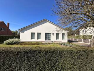 Gelijkvloerse woning, volledig onderkelderd!Indeling : Inkomhal, grote woonkamer (parket – inbouwkachel), keuken met aansluitend een veranda die...