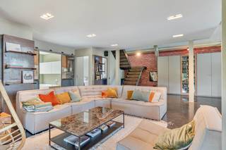 Op zoek naar een ruime, unieke loft met een gigantisch zonnig terras, ideaal gelegen tussen Leuven en Brussel? Dan zit je hier helemaal goed.<br /><br />Ben je een liefhebber van hoge plafonds, een uitgesproken industriële stijl en de combinatie van staal en beton? Dan zal deze uitzonderlijke loft je ongetwijfeld weten te bekoren.<br /><br />Met een bewoonbare oppervlakte van 240 m² en een indrukwekkend terras van 96 m², uitgerust met een vijver en jacuzzi, biedt deze loft een unieke woonbeleving. Ze is gelegen in de voormalige brouwerij "Van Velthem" in Herent, waar authentiek karakter en hedendaags comfort naadloos samenkomen.<br /><br />Via de imposante inkomhal, die volledig tot in de nok is opengetrokken, kom je binnen in de royale leefruimte met een hypergeïnstalleerde open keuken, voorzien van onder meer een inloopkoelkast en een tapkraan. Op dit niveau bevinden zich verder twee ruime slaapkamers, een stijlvolle badkamer met ligbad en een eerste terras.<br /><br />De robuuste stalen trap leidt naar de bovenverdieping, waar een volledig op maat ingericht home office, een gezellige tv-hoek, een ingerichte douchekamer en een derde slaapkamer met Finse sauna en eigen douche zijn ondergebracht.<br /><br />Via een groot schuifraam bereik je het absolute pronkstuk van deze woning: een fenomenaal dakterras van 96 m² met panoramisch uitzicht, een vijver, jacuzzi en alle ruimte om in alle rust te ontspannen of gezellige momenten te beleven met familie en vrienden.<br /><br />Ook op praktisch vlak scoort deze loft uitstekend. Een afgesloten garagebox met bijhorende berging (€35.000) in de ondergrondse kelderverdieping én een privatieve autostaanplaats (€20.000) voor het gebouw zijn optioneel bij aan te kopen, zodat je kan beschikken over twee eigen parkeerplaatsen. Daarnaast geniet je van een gemeenschappelijke fietsenberging en een aangelegde tuin.<br /><br />Een zeldzame kans voor wie op zoek is naar een exclusieve loft met karakter, ruimte, een uitgesproken industriële uitstraling én uitzonderlijk wooncomfort.<br /><br />Bijkomende info (EPC, bodemattest, stedenbouwkundige inlichtingen,...) kan U hieronder downloaden ↓.