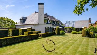 Unieke villa met binnenzwembad, vijver, polyvalente ruimte en garage op 15.399m² te Lier/Koningshooikt. <br /><br />Algemeen:<br />- Mooie villa met binnenzwembad<br />- Gelegen op een prachtig perceel van 15.399 m²<br />- Achtergelegen polyvalente ruimte (ca. 315m²)<br />- Achtergelegen garage/magazijn met aparte ingang (ca. 611 m²)<br />- Conciërgewoning (ca. 105m²) boven polyvalente ruimte<br />- Grote vijver<br />- Woning is deels verbouwd in 2006<br />- Keuken vernieuwd in 2021<br />- Nieuw dak op bijgebouw in 2024<br />- Top EPC score: 120 kWh/m²/jaar (label B)<br />- 102 zonnepanelen op het magazijn<br />- Prachtige orangerie met bbq/haard<br /><br />Indeling:<br />De kwalitatieve villa gelegen met grote leefruimte, eetkamer, keuken, binnenzwembad, bar, sauna, grote tuinkamer/orangerie,... Deze villa beschikt over een mooi aangelegde tuin met grote vijver. Op de eerste verdieping van de woning zijn 5 slaapkamers en 3 badkamers gelegen. In de slaapkamers is bovendien ook airco aanwezig. <br /><br />Daarnaast is er een verbinding op het gelijkvloers tussen de woning en de polyvalente ruimte en het magazijn. Momenteel is het eerste deel ingericht als feestzaal met een bar en verschillende bergingen + garage. De feestzaal heeft een prachtig zicht op de vijver. Achteraan is een groot magazijn aanwezig, deze is toegankelijk via een poort en een aparte in- en uitrit aan de straatkant.<br />Boven de polyvalente ruimte is een conciërgewoning van ca. 105 m² met 2 slk, badkamer, leefruimte met open keuken en terrasje.<br /><br />Voor de exacte indeling bekijk de plannen op onze website.