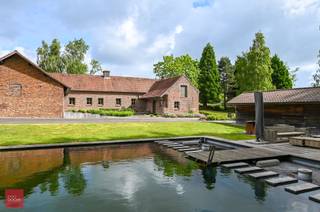 Bestaande uit inkomhal, bureel, living met haard (bio-ethanol, eetplaats, ingerichte keuken, wasplaats, berging, 3 slaapkamers en badkamer. Dubbele carport, tuinberging met sauna, douche en mancave (bar). Tuin met landelijk zicht en ruime zwemvijver. Opp. 4.062m². 48 zonnepanelen + zonneboiler.<br /> 