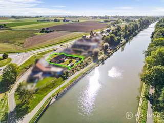 Deze <strong>zeer goed onderhouden gelijkvloerse woning</strong> is gelegen op een<strong> mooi perceel van 937 m²</strong> in Heestert, op de grens met Zwevegem-Knokke, en geniet van een bijzonder <strong>aangename ligging langs het kanaal Bossuit-Kortrijk</strong>.<br />De woning ligt rustig <strong>teruggetrokken van de straat</strong> en combineert deze groene ligging met een <strong>vlotte bereikbaarheid richting Kortrijk en de belangrijkste invalswegen en autosnelwegen</strong>.<br />Dankzij de praktische indeling, drie slaapkamers en volwaardige tuin is dit een comfortabele woning op een<strong> unieke locatie aan het water</strong>.<br /><br /><u><strong>Indeling</strong></u><br />Via de inkomhal met apart toilet kom je binnen in de woonkamer met eetplaats en zithoek.<br />Aansluitend bevindt zich de keuken. De nachthal geeft toegang tot drie slaapkamers en een badkamer.<br />Verder beschikt de woning over een praktische inpandige garage met wasplaats en een ruime zolder die heel wat extra bergruimte biedt.<br />Achteraan bevindt zich de volwaardige tuin met een rustgevend zicht op het kanaal.<br />Het nabijgelegen jaagpad langs het kanaal Bossuit-Kortrijk vormt bovendien een ideale uitvalsbasis voor mooie wandel- en fietstochten langs het water.<br /><br /><u><strong>Technisch</strong></u>
<ul>
<li>Dakisolatie aanwezig</li>
<li>EPC: 459 kWh/(m² jaar) – de woning valt onder de renovatieverplichting</li>
<li>Mogelijkheid om mits beperkte energetische ingrepen aan de renovatieverplichting te voldoen</li>
<li>Niet gelegen in overstromingsgevoelig gebied</li>
<li>Regenwaterput van 10.000L</li>
</ul>
<u><strong>Troeven</strong></u>
<ul>
<li>Zeer goed onderhouden gelijkvloerse woning</li>
<li>Mooi perceel van 937 m²</li>
<li>Prachtige ligging langs het kanaal Bossuit-Kortrijk</li>
<li>Rustig teruggetrokken van de straat</li>
<li>3 slaapkamers op het gelijkvloers</li>
<li>Volwaardige tuin met zicht op het water</li>
<li>Vlotte toegang tot het jaagpad</li>
<li>Praktische garage met wasplaats</li>
<li>Ruime zolder</li>
<li>Vlotte ontsluiting richting Kortrijk en autosnelwegen</li>
</ul>
<u><strong>Contact</strong></u><br />Contacteer Aaron gerust voor meer info of een rondleiding: 0471 89 28 25 - aaron@real-immo.be.<br />Ontdek zelf de rust en unieke ligging van deze woning. <strong>Tot binnenkort!</strong>
