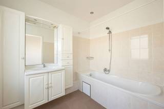 <p><span>Zoek je een appartement in een kleinschalig gebouw waar je zo in kan? Dan zit je hier op de tweede verdieping goed. Denk: lage algemene kosten, individuele nutsvoorzieningen,  twee slaapkamers ( waarvan 1 doorloopkamer ) en een absolute toplocatie net buiten de stad.</span></p><p><span> </span></p><p><span>Je komt het appartement op de tweede verdieping binnen in de centrale hal, waar de aangename retro-tegel meteen opvalt. De inkomhal met parlefoon vormt de spil van het appartement: een centraal punt van waaruit alle leefruimtes mooi op elkaar aansluiten.</span></p><p><span> </span></p><p><span>Twee slaapkamers en keuken met terras</span></p><p><span> </span></p><p><span>Vanuit de inkomhal stap je rechts de lichtrijke leefruimte binnen — een warme, open plek waar de sierhaard en de kamerbrede ramen samen zorgen voor een sfeervol geheel. De woonkamer ligt aan de voorzijde van het gebouw en biedt directe toegang tot de badkamer.</span></p><p><span>De badkamer is volledig betegeld, verzorgd en goed  onderhouden. Dankzij de ingebouwde spots, het ruime badkamermeubel met stijlvolle kasten en spiegel, en het royale ligbad met douchekop vormt dit een aangename plek om te ontspannen.</span></p><p><span> </span></p><p><span>Vanuit de inkomhal bereik je de verzorgde keuken, voorzien van een ijskast, gasvuur, dubbele spoelbak, dampkap en heel wat opbergruimte. Achter de keuken vind je een echte troef: het zonnige, zuidoostgerichte terras met een rustgevend zicht op groen. De ideale plek voor een ontbijtje in de zon of een gezellig avondmoment met wat planten en een tafeltje. Verder in de inkomhal heb je een apart toilet met aansluiting voor was en droog.</span></p><p><span> </span></p><p><span>De slaapkamers bevinden zich aan de rustige achterzijde van het gebouw en hebben allebei dezelfde mooie laminaatvloer. De eerste kamer is een doorloopkamer, die ook kan dienstdoen als lichte thuiswerkplek, met erachter de master bedroom, die voldoende plaats heeft voor een dubbel bed, een grote kast en nog een bureauhoekje bijvoorbeeld.</span></p><p><span> </span></p><p><span> </span></p><p><span>Net buiten de stad, met alles in de buurt</span></p><p><span>Je woont hier in de Joe Englishstraat , een rustige straat met groen  in een gegeerde wijk in</span></p><p><span>Borgerhout, net buiten de Ring. De tram en de bussen voor je deur brengen je zo  in en weer uit de stad. Je hebt hier allerlei supermarkten, een apotheek, buurtwinkeltjes, scholen, etc. opwandelafstand. Zin in groen? Zowel in het Rivierenhof als het Te Boelaerpark ben je zo!</span></p><p><span> </span></p>