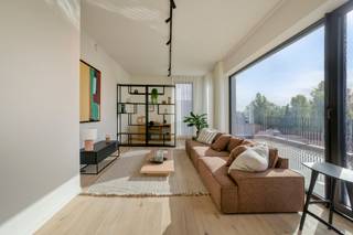 Exclusief en instapklaar penthouse in hartje Merelbeke – wonen in alle rust, comfort en luxe
Droomt u van een uniek penthouse waar ruimte, licht, comfort en een uitstekende ligging perfect samenkomen? Dan is dit prachtige, instapklare penthouse in het hart van Merelbeke absoluut een bezoek waard.
Gelegen in het stijlvolle en kleinschalige nieuwbouwproject De Wisselaar, biedt dit bijzondere appartement een uitzonderlijke woonbeleving op een toplocatie. De royale raampartijen zorgen voor een overvloed aan natuurlijk licht en versterken het aangename, open gevoel in de ruime leefruimtes. De warme uitstraling van de parketvloer, de verzorgde afwerking en het feit dat het penthouse volledig professioneel geschilderd werd, maken dat u hier zonder zorgen meteen kunt intrekken.
Een absolute troef is het prachtige, brede en zuidgerichte terras. Hier geniet u volop van de zon, van een rustig ontbijt tot lange, gezellige avonden buiten. De aanwezige zonwering en zonneluifel zorgen bovendien voor extra comfort op warme dagen.
Het penthouse beschikt over twee volwaardige slaapkamers en twee badkamers.
Ook op praktisch vlak ontbreekt het u aan niets. Er is een ruime fietsenberging op het gelijkvloers en een private kelderberging (aan te kopen). Daarnaast koopt u uw eigen garagebox en kan ook een staanplaats bij aangekocht worden.
Een groene, autovrije omgeving in volle ontwikkeling
Wat deze locatie extra bijzonder maakt, is de prachtige omgeving die hier verder wordt gerealiseerd. Het plein voor het project wordt groen en sfeervol aangelegd, met beplanting en wadi’s die bijdragen aan een aangename, duurzame leefomgeving. De publieke ruimte wordt autovrij ingericht, met aandacht voor voetgangers en fietsers. Ook in de onmiddellijke omgeving zijn er parkeermogelijkheden, waaronder een groene parking en de gemeentelijke parking.
Bovendien bevindt u zich hier op wandelafstand van winkels, horeca, diensten en alle dagelijkse voorzieningen. U woont dus midden in Merelbeke, met alles binnen handbereik en tegelijk in een aangename, groene omgeving.
Het project is bovendien ontworpen met aandacht voor duurzaam en toekomstgericht wonen, zonder fossiele brandstoffen en volgens de toepasselijke regelgeving. Een belangrijke troef voor wie vandaag bewust kiest voor comfort en energiezuinigheid.
Een unieke kans in een project met uitstraling
De Wisselaar is een bijzonder woonproject waar kwaliteit, architectuur en een aangename leefomgeving centraal staan. Intussen is al 90 % van het project verkocht, wat de aantrekkingskracht ervan onderstreept.
De omgeving heeft alles in zich om uit te groeien tot een levendige en gegeerde plek in Merelbeke: een mooie combinatie van wonen, groen, bereikbaarheid en voorzieningen.
Ontdek zelf de charme van dit bijzondere penthouse en laat u verrassen door de ruimte, het licht en de unieke ligging.
Exclusief te koop aangeboden via de Oximo online verkoopsprocedure. Voor registratie en aanvaarding van de verkoopsvoorwaarden zie www.oximo.be.
