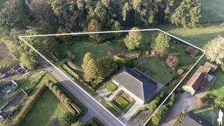 <strong>Deze uitstekend onderhouden vrijstaande woning combineert ruimte, comfort en een uitzonderlijke ligging in het groen. Gelegen op een perceel van maar liefst 4.041 m² geniet u hier in alle rust van een prachtig uitzicht over de achterliggende weilanden. De sfeervol aangelegde tuin met pergola vormt de ideale plek om in alle privacy te ontspannen en volop te genieten van de natuur rondom u.<br /><br /></strong>De woning biedt een bewoonbare oppervlakte van ca. 245 m² en is volledig gelijkvloers ingericht. Via de inkomhal bereikt u de ruime woonkamer met warme parketvloer. Dankzij de grote raampartijen baadt deze leefruimte in natuurlijk licht. Een schuifraam biedt directe toegang tot het terras en de tuin. De houtkachel zorgt bovendien voor extra sfeer en gezelligheid.<br /><br />De volledig geïnstalleerde keuken is uitgerust met onder andere een Siemens oven, een vaatwasmachine en een microgolfoven. Daarnaast beschikt de keuken over voldoende kastruimte. Vanuit de keuken geniet u van een prachtig zicht op de verzorgde tuin en de omliggende weilanden.<br /><br />Verder beschikt de woning over vier volwaardige slaapkamers op het gelijkvloers. De badkamer is voorzien van een douche, ligbad, dubbele wastafel en toilet. Daarnaast is er nog een apart gastentoilet aanwezig.<br /><br />Via een vaste trap bereikt u de zolderverdieping, die reeds gedeeltelijk werd ingericht. Hier kan eenvoudig een vijfde slaapkamer, hobbyruimte of bureau worden gecreëerd. Ook de praktische kelder, bereikbaar via een vaste trap, biedt heel wat extra opslagruimte.<br /><br />De inpandige garage beschikt over een automatische poort en biedt plaats aan uw wagen. Tevens bevinden zich hier de aansluitingen voor wasmachine en droogkast.<br /><br />De absolute blikvanger van deze woning is zonder twijfel de prachtig aangelegde tuin. Dankzij de royale perceeloppervlakte, de rustige ligging en het weidse uitzicht over de achterliggende velden geniet u hier elke dag van een uniek gevoel van ruimte, rust en privacy.<br /><br /><span>Bijzonderheden:</span><br />
<ul>
<li>Perceel van 4.041 m²</li>
<li>Rustige ligging met uitzicht op agrarisch gebied</li>
<li>Mogelijkheid tot vijfde slaapkamer op zolder</li>
<li>Praktische kelder met veel bergruimte</li>
<li>Volop rust, privacy en groenbeleving gegarandeerd</li>
<li>Prachtig aangelegde tuin met pergola</li>
</ul>
<div>Deze woning is een unieke kans voor wie op zoek is naar comfortabel wonen in alle rust, omringd door groen en met een adembenemend uitzicht op de omliggende natuur.</div>