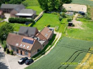 Op een rustige en landelijke locatie in Sint-Pieters-Kapelle (Pajottegem) bevindt zich deze ruime, energiezuinige, halfopen bebouwing met een bebouwde oppervlakte van maar liefst 285 m². De woning met een afzonderlijk weiland en een prachtig open zicht werd volledig gerenoveerd en combineert hedendaags wooncomfort met een uitzonderlijke ligging te midden van de uitgestrekte Pajotse velden en de watertoren. Als extra troef beschikt de eigendom over een afzonderlijk weiland van 14a10ca aan de overzijde van de straat. Bij het betreden van de woning wordt u verwelkomd in een lichtrijke leefomgeving waar ruimte en comfort centraal staan. De moderne open keuken met centraal eiland vormt het hart van de woning en biedt dankzij de grote raampartijen een prachtig zicht op het omliggend landschap en de watertoren. De indeling en de beschikbare ruimtes maken deze woning bovendien interessant voor wie wonen en werken wenst te combineren (thuisbureau, vrij beroep,…). De woning beschikt over 3 ruime slaapkamers en 2 badkamers met inloopdouche waarvan 1 badkamer op het gelijkvloers nog verder naar eigen smaak kan worden ingericht. Buiten geniet u van een verzorgde aangelegde tuin, een ruim zonneterras, een inpandige garage en een grote, hoge carport. Het afzonderlijke weiland biedt bovendien tal van mogelijkheden voor liefhebbers van natuur, dieren of extra buitenruimte. Ook op technisch vlak scoort deze woning uitstekend dankzij de aanwezigheid van een warmtepomp, zonnepanelen, een conforme elektrische installatie, een asbestveilig attest en een gunstig EPC-label A. Deze eigendom biedt een unieke combinatie van ruimte, rust, energiezuinigheid en hedendaags wooncomfort op een uitzonderlijke locatie met panoramisch uitzicht. Vraag nu meer informatie of plan uw bezoek 054/69.68.67.