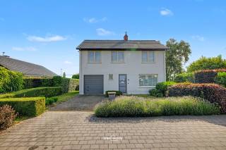 In een rustige doodlopende straat in Haasdonk bevindt zich deze open bebouwing op een mooi perceel met veel privacy. Dankzij de combinatie van ruimte, een gunstige EPC-score en een uitstekende ligging nabij het centrum en de E17 vormt deze woning een ideale thuisbasis voor gezinnen.<br /><br />Bij het binnenkomen word je verwelkomd in een inkomhal met vestiaire en gastentoilet. Van hieruit bereik je de gezellige leefruimte, met open haard. Hier zorgen de grote raampartijen voor veel natuurlijke lichtinval en een mooi zicht op de tuin. Aansluitend bevindt zich de keuken, die voldoende ruimte biedt en ook zicht op de tuin.<br /><br />Verder beschikt het gelijkvloers over een inpandige garage met extra bergruimte.<br /><br />Op de verdieping bevinden zich vier ruime slaapkamers en een badkamer uitgerust met ligbad, dubbele lavabo en toilet. Via een uitschuifbare trap bereik je de praktische zolderruimte.<br />Buiten geniet je van een ruime verzorgde tuin. De twee terrassen zorgen ervoor dat je op elk moment van de dag een aangename plek in de zon of schaduw vindt. Daarnaast is er nog een tuinhuis aanwezig.<br /><br />Extra troeven:<br />-	EPC C – geen renovatieplicht<br />-	Open bebouwing in kindvriendelijke woonwijk<br />-	4 ruime slaapkamers<br />-	Inpandige garage<br />-	Buitenmuren geïsoleerd<br />-	Aluminium ramen met hoogrendementsglas<br />-	Twee terrassen en ruim tuinhuis<br />-	Vlotte verbinding naar E17, Antwerpen en Gent<br /><br />Een woning met sterke basis, veel ruimte en een uitstekende ligging voor wie rustig wil wonen zonder in te boeten op bereikbaarheid.<br /><br />Interesse? Contacteer ons via 052 46 38 03 voor meer informatie of een bezoek.<br />