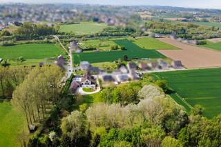 Slechts zelden komt een eigendom van dit kaliber op de markt. Gelegen op een benijdenswaardige locatie in Schepdaal bieden wij u dit authentieke landhuis uit negentienhonderd dertig aan. Deze karaktervolle woonst onderging een recente en uiterst grondige totaalrenovatie waarbij kosten noch moeite werden gespaard om historische grandeur te verenigen met hedendaagse luxe en duurzaamheid. Het resultaat is een indrukwekkend domein met een bewoonbare oppervlakte van maar liefst zeshonderd vierkante meter, gesitueerd in een eigen park van bijna een hectare.<br /><br />Wat dit pand werkelijk uniek maakt in zijn segment is de energetische score. Voor een vrijstaande woning van deze omvang en historiek is een EPC label C ronduit uitzonderlijk. Dit is het resultaat van een doordachte isolatiestrategie en de integratie van moderne technieken, waardoor u geniet van een optimaal wooncomfort met een beheersbare ecologische voetafdruk.<br /><br />Bij het betreden van de woning valt onmiddellijk de enorme schaal op. De woon en eetkamer beslaan samen een indrukwekkende oppervlakte van circa honderddertig vierkante meter. Deze ruimte vormt het kloppende hart van het huis en ademt klasse uit. De volledig uitgeruste keuken is een droom voor elke culinaire liefhebber, badend in natuurlijk licht en met een panoramisch uitzicht op de prachtig aangelegde tuin.<br /><br />Voor de professional is er een kantoor voorzien dat direct uitkijkt op het verwarmde zwembad. Deze werkplek is bovendien uitgerust met een aparte archiefruimte en een eigen zithoek, wat het de ideale plek maakt voor discretie en focus. <br /><br />Praktisch gemak wordt geboden door een uitzonderlijk ruime wasplaats van zevenentwintig vierkante meter.<br /><br />Met vijf ruime slaapkamers en drie badkamers biedt het hoofdgebouw alle ruimte voor een groot gezin en gasten. Als extra troef beschikt het pand over een volwaardige en onafhankelijke studio van zestig vierkante meter. Met een eigen ingang, ingerichte keuken, woonkamer en badkamer leent deze ruimte zich perfect voor een au pair, inwonende ouders of een privaat gastenverblijf.<br /><br />De beleving begint reeds bij de private inrit die u naar het landgoed leidt. De parkeermogelijkheden zijn ongezien: u beschikt over drie inpandige garages en een ruime carport die eveneens plaats biedt aan drie wagens. Of u nu een verzamelaar bent of veel gasten ontvangt, aan ruimte is hier geen gebrek.<br /><br />De totale grondoppervlakte van negenduizend zevenhonderd vierkante meter transformeert de tuin tot een privaat park. U geniet hier van een absolute privacy en een rustgevend groen uitzicht zover het oog reikt. Het verwarmde zwembad vormt de kers op de taart voor ontspanning tijdens de zomermaanden.<br /><br />Dit pand is meer dan een woning; het is een statement van tijdloze elegantie en modern wooncomfort. Een unieke kans voor wie op zoek is naar ongeziene ruimte en privacy op een steenworp van Brussel.<br /><br />Ontdek dit meesterwerk zelf en maak een afspraak voor een private rondgang.<br /><br />📩 Contacteer Nils vandaag nog via 0497 248 251 voor meer informatie of een bezoek ter plaatse!<br /><br />Stedenbouwkundige inlichtingen in aanvraag.