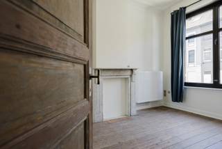 In het hart van Kortrijk bevindt zich deze prachtige authentieke stadswoning met een stijlvolle gevel, deel uitmakend van een karaktervolle eenheidsbebouwing van vijf enkelhuizen uit het begin van de 20ste eeuw. Deze woning combineert de charme van weleer met het hedendaagse wooncomfort.<br /><br />Via de inkomhal komt u in de lichtrijke leefruimte, waar de hoge plafonds, de authentieke houten vloeren en de grote raampartijen onmiddellijk in het oog springen. De volledig vernieuwde open keuken sluit perfect aan op de woonkamer en biedt rechtstreeks toegang tot het terras en zicht op de gezellige stadstuin.<br /><br />Op de eerste verdieping bevinden zich twee ruime slaapkamers en een apart toilet. De tweede verdieping beschikt over een volledig vernieuwde badkamer met ligbad, ruime inloopdouche en modern badkamermeubel, evenals een derde volwaardige slaapkamer. Bovendien is de woning volledig uitgerust met centrale verwarming, aangestuurd door een nieuwe condenserende verwarmingsketel, wat garant staat voor een energiezuinig en comfortabel binnenklimaat.<br /><br />Verder beschikt de woning over een volledig geïsoleerde zolder, ideaal als extra bergruimte, en een halfondergrondse kelder die is ingericht als wasberging en tevens voldoende plaats biedt voor de stockage van fietsen.<br /><br />De woning werd recent volledig geschilderd en is instapklaar. Voor de oplevering worden nog passende verlichtingsarmaturen geplaatst en zal de tuin professioneel worden gesnoeid, zodat alles netjes afgewerkt is.<br /><br />Een unieke kans voor wie op zoek is naar een charmante en instapklare stadswoning met een eigen verhaal.<br /><br />Vrij op 01/09/2026.<br /><br />Waarom net dit aanbod overwegen?<br /><br />✔ authentieke gevel uit het begin van de 20ste eeuw<br />✔ centrumligging<br />✔ vernieuwde keuken en badkamer<br />✔ 3 volwaardige slaapkamers<br />✔ stadstuin<br />✔ geschilderd<br />✔ hoge plafonds <br />✔ veel lichtinval<br />✔ nieuwe condensatieketel<br /><br />Geïnteresseerd? Vul eenvoudig het contactformulier in en we nemen spoedig contact op.