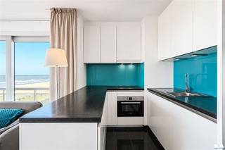 MODERN BEACHFRONT APARTMENT WITH OCEAN VIEW IN MIDDELKERKEThis stylishly furnished apartment is ideal for those who love comfort and a beachfront lifestyle in Middelkerke. With an open-concept kitchen and living area, an elegant sitting area, and direct ocean views, this home offers the perfect balance between compact living and luxury.INTERIOR HIGHLIGHTSThe living area combines a fully equipped kitchen with modern, high-quality finishes. The black-and-white design, accented with turquoise, lends a contemporary, sophisticated character. The kitchen features a built-in oven, a fridge-freezer, and practical countertops in a dark finish. The open layout makes the space feel larger and creates a cozy atmosphere that blends cooking and relaxation.The sitting area is comfortably furnished with stylish, substantial armchairs and a coffee table, perfect for relaxation. A bedroom equipped with built-in closets and LED lighting offers a soothing retreat. A modern bathroom with a shower, sink, and mirror completes the space with a minimalist, hygienic design.OCEAN VIEW AND OUTDOOR SPACELarge windows and sliding doors offer a panoramic view of the beach and the ocean. LOCATIONThis apartment is located in a modern complex in Middelkerke, right on the famous Belgian coast. The beach is literally right outside your door, perfect for beach lovers, athletes, and families. The nearest amenities, restaurants, and shops are easily accessible.IDEAL FORThis is an ideal place for couples, professionals, or small families looking for a compact, fully furnished space with a premium ocean view. Perfect as a tourism investment or as a permanent residence.