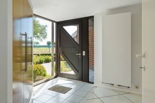 Deze goed onderhouden, vrijstaande woning is heerlijk rustig gelegen met het uitzicht op velden en weilanden. Niettegenstaande de landelijke ligging, zijn de centra van zowel Stabroek, Kapellen als Putte snel en vlot bereikbaar. U komt de woning binnen via een ruime inkomhal, voorzien van handige ingemaakte kasten en een gastentoilet. Vanuit de inkomhal loopt u verder door naar de gigantische open leefruimte met zithoek op parketvloer en woonkamer, eetkamer en keuken op tegelvloer. Grote raampartijen en schuiframen zorgen ervoor dat de gehele ruimte baadt in het daglicht. Aan de achterzijde werden tevens zonnescreens voorzien. De gerieflijke open keuken werd voorzien van alle comfort. Via de trap bereikt u de open vide op de 1e verdieping. Deze vormt de verbinding tussen de 2 gigantische slaapkamers, waarvan één eenvoudig kan worden opgesplitst in 2 volwaardige kamers, en de luxueuze badkamer. Deze laatste is voorzien van een groot, rond bad, een douche, een toilet, een bidet, een handdoekdroger en 3 lavabo's met meubel. Verder beschikt de woning nog over een grote kelder, dewelke heel wat opbergruimte biedt en waar u ook nog een bureau kan terugvinden. De inpandige garage met automatische poort biedt ruimschoots plaats aan uw wagen. Ze is tevens ook voorzien van een smeerput en u kan er de aansluitingen voor wasmachine en droogkast terugvinden. Een achterdeur geeft vanuit de garage rechtstreeks toegang tot de tuin. Ook de oprit voor de woning is voldoende ruim om een extra wagen te parkeren. Een absolute troef van deze woning is het bijzonder ruime perceel van maar liefst 1.745 m². De riante tuin biedt volop ruimte om in alle rust en privacy te genieten van de buitenlucht en het zonnetje. Met een aangelegd terras, een gezellige overkapping en een groot zwembad is het hier heerlijk vertoeven tijdens zonnige dagen. De tuin is uitgerust met een sproei-installatie die gebruikmaakt van grondwater.
