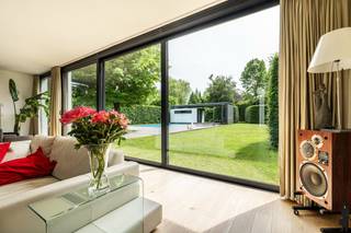 <p><strong>Exclusieve villa met zwembad op een uitzonderlijk perceel in een rustige woonomgeving te Malle</strong></p>
<p>In een bijzonder <strong>rustige</strong> en <strong>groene omgeving</strong> van <strong>Malle</strong> bevindt zich deze <strong>ruime</strong>, <strong>instapklare villa</strong> op een <strong>prachtig perceel</strong> met <strong>zwembad</strong>, <strong>royale leefruimtes</strong> en een <strong>volledig onderkelderde</strong> constructie. Dankzij de combinatie van <strong>hoogwaardige afwerking</strong>, <strong>energiezuinige technieken</strong> en een uitzonderlijk <strong>wooncomfort</strong> is deze eigendom een unieke opportuniteit voor wie ruimte en kwaliteit zoekt. De woning is bovendien uitgerust met een <strong>alarmsysteem</strong>, <strong>omkeerbare airconditioning</strong> en <strong>screens aan de zuidkant</strong>, wat bijdraagt aan het comfort en de veiligheid.</p>
<p>Bij het betreden van de woning komt u terecht in een <strong>ruime inkomhal</strong> met gastentoilet en toegang tot de verschillende leefruimtes. De <strong>lichtrijke woonkamer</strong> met aansluitende <strong>eetruimte</strong> geniet van grote raampartijen en een aangename connectie met de tuin. De <strong>ruime leefkeuken</strong> vormt het hart van de woning en biedt alle mogelijkheden voor gezellige familiemomenten. Verder bevinden zich op het gelijkvloers een <strong>kantoorruimte</strong>, een aparte <strong>tv-hoek</strong>, een praktische <strong>wasplaats</strong> en een <strong>inpandige garage</strong>. Dankzij de aparte <strong>praktijk- of kantoorruimte</strong> is deze woning bovendien uitermate geschikt voor wie wonen en werken wil combineren.</p>
<p>Op de eerste verdieping beschikt de villa over maar liefst <strong>vijf ruime slaapkamers</strong>. De <strong>master suite</strong> omvat een royale hoofdslaapkamer, een <strong>dressing met ingemaakte kasten</strong> en een <strong>luxueuze badkamer</strong>. Daarnaast zijn er nog <strong>twee extra badkamers</strong> en een afzonderlijk toilet, wat zorgt voor <strong>optimaal comfort</strong> voor een groot gezin. Een ruime <strong>hobbykamer</strong> biedt tal van mogelijkheden als <strong>speelkamer</strong>, <strong>fitnessruimte</strong>, <strong>atelier</strong> of extra <strong>bureauruimte</strong>. Het <strong>zonnige balkon</strong> vervolledigt deze verdieping.</p>
<p>Een absolute troef is de <strong>volledig onderkelderde verdieping</strong> met meerdere afzonderlijke <strong>kelderruimtes</strong> en <strong>wijnkelder</strong>.</p>
<p>Buiten geniet u van een prachtig aangelegde <strong>zuidgerichte tuin</strong> met <strong>veel privacy</strong>, een <strong>verwarmd zwembad</strong> en <strong>poolhouse</strong>, waar rust en ontspanning centraal staan. Het ruime perceel biedt voldoende plaats voor kinderen om te spelen, tuinliefhebbers om zich uit te leven en gasten te ontvangen tijdens lange zomeravonden.</p>
<p>Ook op technisch vlak scoort deze woning uitstekend. De villa is bijzonder <strong>energiezuinig</strong> dankzij een combinatie van <strong>kwalitatieve isolatie</strong>, <strong>zonnepanelen</strong>, <strong>thuisbatterijen</strong> en een <strong>warmtepomp</strong>, wat resulteert in een <strong>duurzame</strong> en <strong>toekomstgerichte woonervaring</strong>.</p>
<p><strong>Troeven</strong></p>
<ul>
<li>Energiezuinig (isolatie, zonnepanelen, thuisbatterijen en warmtepomp)</li>
<li>Zuidgerichte tuin met veel privacy</li>
<li>Verwarmd zwembad met poolhouse</li>
<li>Inpandige garage</li>
<li>Volledig onderkelderd</li>
<li>Ingemaakte kasten</li>
<li>Praktijk- of kantoorruimte aan huis mogelijk</li>
<li>Alarmsysteem</li>
<li>Mogelijkheid tot bijverwarming</li>
</ul>
<p>Een unieke villa waar ruimte, comfort en een uitstekende ligging samenkomen. Een bezoek is absoluut de moeite waard.</p>