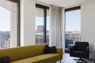 <p>Op de zevende verdieping van deze moderne residentie aan het Kattendijkdok ligt dit prachtig afgewerkt appartement met een uitzonderlijk panoramisch zicht over de stad Antwerpen, het MAS, het Havenhuis en het Kattendijkdok. Een absolute troef voor wie wil wonen in het hart van het bruisende Eilandje én op wandelafstand van de Schelde, de historische binnenstad en tal van gezellige horecazaken.</p>
<p>De open woonkamer, eetruimte en keuken vormen samen een aangename, lichtrijke ruimte die wordt omzoomd door imposante ramen van vloer tot plafond. Waar u ook zit, telkens opent zich een weids uitzicht. Voldoende plaats voor een comfortabele zithoek en een eettafel, met de open keuken als warm middelpunt van de woonst. De volledig geïnstalleerde keuken is stijlvol afgewerkt met marmeren werkbladen en een ruim kookeiland, aangevuld met kwalitatieve ingebouwde toestellen. <br />Het appartement telt twee slaapkamers. De hoofdslaapkamer beschikt over een praktische eigen dressing, terwijl de tweede slaapkamer voldoende flexibiliteit biedt voor kinderen, een thuiskantoor of een logeerkamer. De badkamer is tevens hoogwaardig afgewerkt met marmeren tegels, een ruime inloopdouche en dubbele wastafel — een verzorgd geheel met een luxueuze uitstraling.</p>
<p>Een echte meerwaarde van dit appartement zijn de twee terrassen, georiënteerd op het zuiden en het zuidwesten. Op de terrassen geniet u van een open zicht over de stad, het MAS, het Kattendijkdok en de skyline van de haven. Ideaal om buiten te ontbijten, te lunchen of ‘s avonds na te genieten van de laatste zonnestralen.</p>
<p><strong>Extra troeven</strong></p>
• Hoge berging naast de liften<br />• Dubbele ondergrondse staanplaats met laadpaal van 22 kW te koop aan €45.000<br />• Centrale ligging nabij winkels, horeca en openbaar vervoer<br />• Tijdloze afwerking met natuursteen doorheen het volledige appartement