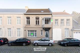 Gelegen in de Vleeschouwersstraat, op amper 100 meter van de Grote Markt van Veurne, bevindt zich deze volledig gerenoveerde en beschermde herenwoning. Dankzij de centrale ligging bevinden scholen, winkels, horeca, openbaar vervoer en alle dagelijkse voorzieningen zich op wandelafstand.<br /><br />De woning is volledig instapklaar en beschikt over 3 slaapkamers en 2 badkamers. Dankzij de ruime indeling is ze geschikt als gezinswoning, maar biedt ze ook mogelijkheden voor wie een combinatie zoekt met een bureau of een vrij beroep.<br /><br />Op het gelijkvloers komt u binnen via de royale inkomhal, met afzonderlijk gastentoilet. Vanuit de inkomhal heeft u toegang tot de slaapkamer en de bureauruimte. De huidige bureauruimte is voorzien van een gashaard en kan uiteraard ook als derde slaapkamer worden ingericht. Verder is er toegang tot de gezellige binnenkoer, met aansluitend een praktische berging met voorzieningen voor wasmachine en droogkast.<br /><br />De slaapkamer op het gelijkvloers beschikt over een eigen badkamer met douche, wat deze verdieping extra praktisch maakt.<br /><br />Via de trap bereikt u de eerste verdieping, waar de ruime en bijzonder lichtrijke leefruimte zich bevindt. De hoge plafonds en grote raampartijen zorgen hier voor een aangenaam ruimtelijk gevoel. De leefruimte is voorzien van een hoogwaardige parketvloer en sluit aan op de volledig geïnstalleerde open keuken met ontbijtmeubel.<br /><br />Op deze verdieping bevindt zich eveneens de tweede badkamer, uitgerust met een douche, bad, enkele wastafel en toilet.<br /><br />De tweede verdieping omvat twee ruime slaapkamers, beide voorzien van ingemaakte kasten. Via de nachthal is er toegang tot de zolder, die extra bergruimte biedt.<br /><br />Achteraan de woning bevindt zich een gezellig terras, een aangename plek om in alle rust van de buitenlucht te genieten.<br /><br />Ook op energetisch vlak beschikt de woning over een goede basis. Er is centrale verwarming op aardgas, het dak werd geïsoleerd en de woning beschikt over dubbele beglazing in houten schrijnwerk.<br /><br />Een karaktervolle woning met veel ruimte, licht en mogelijkheden, gelegen op een bijzonder centrale locatie in het hart van Veurne.<br /><br />Voor meer informatie of een bezoek kunt u contact opnemen met Inti via inti@immofrancois.be of 0499 74 89 74.<br /><br />