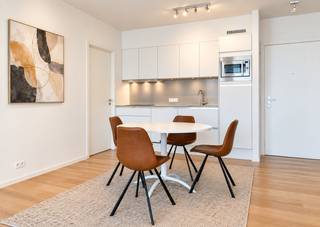 An exceptional flat of approximately 68 m² on the third floor of the stunning Melopee residence. This building, designed by Crepain Binst Architecture on the corner of Rijnkaai and Amsterdamstraat, immediately catches the eye. Its greatest asset is undoubtedly its location, offering unobstructed views of the Scheldt and the city, a sense of spaciousness thanks to the wide streets, and its position at the head of the Eilandje, serving as a natural gateway to the neighbourhood’s vibrant cultural and artistic life.
The flat features high-quality parquet flooring throughout and has been finished to the highest standard.
In the living area, you can enjoy the beautiful, unobstructed view of the Scheldt undisturbed thanks to the large, floor-to-ceiling sliding windows. This opens onto the sun terrace of approximately 5m². The open-plan kitchen is fully fitted and equipped with a hob, oven, fridge and dishwasher. A separate utility room has connections for a washing machine and tumble dryer and provides ample storage space.
The bedroom is cleverly laid out and adjoins a dressing room with ample space for large wardrobes. The bathroom features a walk-in rain shower, washbasin and toilet.
A parking space in the underground garage is available to rent for 150 euros per month.
Monthly charges: 120 euros.
All utilities (water, electricity and gas) are to be met privately by the tenant.
Available immediately.