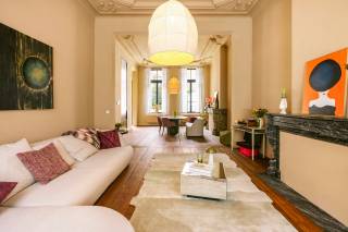 In de Keizer Karelstraat, op een bijzonder centrale ligging in Gent, bevindt zich dit uitzonderlijke duplexappartement van maar liefst 229 m², ondergebracht in een karaktervol herenhuis uit de 19de eeuw. Een eigendom waar indrukwekkende volumes, authentieke elementen en een grondige vernieuwing bijzonder mooi samenkomen.<br /><br />Het appartement strekt zich uit over het gelijkvloers en de sous-sol en werd de voorbije periode grondig vernieuwd. Zo werd een volledig nieuwe keuken geplaatst, werd de badkamer volledig vernieuwd, werden de authentieke vloeren zorgvuldig gerestaureerd en werd het volledige appartement opnieuw geschilderd. Daarbij werd bewust gekozen om het oorspronkelijke karakter van het herenhuis te bewaren.<br /><br />En dat karakter is overal aanwezig. Hoge plafonds, authentieke moluren en rozetten, karaktervolle schouwelementen, gerestaureerde vloeren en grote raampartijen geven het appartement een uitstraling die je bij nieuwbouw simpelweg niet kunt creëren.<br /><br />De bijzonder royale open leef- en eetruimte vormt het hart van het appartement. De grote volumes en plafondhoogtes zorgen hier voor een indrukwekkend ruimtegevoel. Aansluitend bevindt zich de vernieuwde keuken, vanwaar je rechtstreeks toegang hebt tot één van de buitenruimtes.<br /><br />Op de sous-sol bevinden zich vier afzonderlijke slaapkamers, waarvan de twee achterste toegang bieden tot een tweede buitenruimte. Daarnaast bevindt zich hier de volledig vernieuwde badkamer.<br /><br />Met zijn 4 tot 5 mogelijke slaapkamers en maar liefst 229 m² bewoonbare oppervlakte biedt dit appartement uitzonderlijk veel ruimte. Niet alleen voor een groot gezin, maar bijvoorbeeld ook voor wie wonen en werken wil combineren.<br /><br />Ook cohousing behoort tot de mogelijkheden. Het appartement beschikt over een conformiteitsattest voor bewoning door maximaal 10 personen. Bovendien is in elke slaapkamer reeds wateraanvoer en afvoer voorzien, wat bijkomende mogelijkheden biedt naar de toekomst toe.<br /><br />Ook het gebouw zelf krijgt verdere aandacht: de renovatie van de gevel én de renovatie van de gemeenschappelijke inkomhal zijn inbegrepen in de verkoopprijs. Hierdoor wordt niet alleen het appartement zelf, maar ook de uitstraling van het herenhuis verder opgewaardeerd.<br /><br />Wie met de wagen komt, heeft bovendien de mogelijkheid om een parkeerplaats in de omgeving te huren.<br /><br />Ook de ligging vormt een belangrijke troef. Het historische centrum, winkels, horeca, scholen en openbaar vervoer bevinden zich op wandel- en fietsafstand. De nabijgelegen Reep en Portus Ganda behoren tot een bijzonder aantrekkelijk stukje Gent langs het water. Bovendien blijft deze omgeving verder evolueren, onder meer door de geplande herontwikkeling van de Portus-site, waardoor deze zijde van de binnenstad de komende jaren nog verder wordt opgewaardeerd.<br /><br />Dit is geen doorsnee stadsappartement. Het is een eigendom voor wie op zoek is naar uitzonderlijk veel woonoppervlakte, authentieke architectuur en hedendaags comfort op een centrale locatie in Gent.<br /><br />Met 229 m², meerdere slaapkamers, twee buitenruimtes en een grondige vernieuwing biedt dit herenhuisappartement vooral iets wat in de Gentse binnenstad steeds moeilijker te vinden is: ruimte zonder het karakter te moeten opgeven.