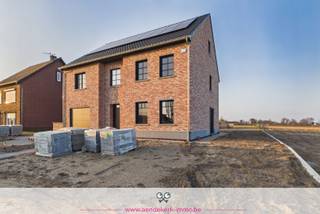 Huurprijs: 2.300 EUR per maand<br />Beschikbaarheid: onmiddellijk<br /><br />In Ophoven, een rustige deelgemeente van Kinrooi op een boogscheut van de Nederlandse grens, staat deze gloednieuwe woning te huur. Een plek waar rust geen privilege is, maar de dagelijkse realiteit. Zicht op de weilanden, geen drukte rondom je — en jij als allereerste bewoner van deze ruime woning.<br /><br />Wie binnenstapt, voelt meteen de logica van de indeling. Keuken en woonkamer vormen één lichtrijk geheel, met de keuken als natuurlijk middelpunt. Grote raampartijen verbinden de leefruimte met de tuin en het omliggende groen — binnen en buiten vloeien in elkaar over.<br /><br />Met een bewoonbare oppervlakte van ca. 275 m² biedt deze woning meer dan voldoende ruimte voor een gezin of voor wie bewust kiest voor ruim wonen.<br /><br />Troeven op een rij:<br />- 5 slaapkamers, verdeeld over de eerste verdieping en de zolderverdieping<br />- twee badkamers en twee toiletten<br />- een kelderverdieping van meer dan 100 m², met rechtstreekse toegang voor fietsen<br />- een inpandige garage en 2 extra parkeerplaatsen voor de woning<br />- gunstige energieprestatie | EPC bouw in opmaak<br />- zonnepanelen<br /><br />De ligging spreekt voor zich, zeker voor wie dagelijks de grens oversteekt. Ophoven ligt vlak bij Nederland, met een vlotte verbinding naar de regio Roermond en omgeving. Tegelijk geniet je hier van het echte Limburgse buitenleven: ruimte, groen en stilte.<br /><br />De tuin sluit naadloos aan op het achterliggende landschap. Of je nu buiten wil zitten, de kinderen wil zien spelen of gewoon wil uitkijken op weilanden — hier kan het nog.