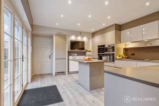Op zoek naar <strong>net dat tikkeltje meer?</strong> Dan is deze uitzonderlijke villa van maar liefst 260 m² bewoonbare oppervlakte exact wat je zoekt. Gelegen in <strong>een rustige woonwijk</strong> aan de rand van Waregem, combineert deze woning ruimte, <strong>luxe </strong>en een uiterst centrale ligging. Horeca, scholen, openbaar vervoer en het centrum van Waregem bevinden zich allemaal op een boogscheut.<br />Je wordt verwelkomd in een <strong>imposante inkomhal</strong> die meteen de toon zet. Het gelijkvloers beschikt over twee slaapkamers (momenteel ingericht als één ruime master bedroom), een lichtrijke leefruimte met gezellige gashaard en een volledig uitgeruste keuken <strong>tot in de puntjes afgewerkt</strong> met o.a. vaatwas, kookplaat, ingebouwde koffiemachine, frigo, microgolfoven, oven en een praktisch keukeneiland.<br /><br />Verder vind je op het gelijkvloers nog een <strong>derde slaapkamer</strong>, een stijlvolle badkamer met inloopdouche, ligbad en lavabomeubel, een apart gastentoilet én een handige berging/wasplaats.<br /><br />De bovenverdieping is ingericht als <strong>een volwaardige aparte woonentiteit</strong>, compleet met leefruimte, eetplaats, kitchenette, <strong>vierde slaapkamer</strong> en een tweede badkamer. Ideaal voor co-housing, een praktijk aan huis, extra slaapmogelijkheden of een hobbyruimte – <strong>de mogelijkheden zijn eindeloos</strong>.<br /><br />Achteraan geniet je van een prachtig aangelegde tuin met vijver, waar rust en privacy centraal staan. De absolute kers op de taart? Een volledig ingericht <strong>poolhouse </strong>met keuken, sauna en inloopdouche – <strong>pure ontspanning in eigen tuin</strong>.
<ul>
<li>Inpandige garage + carport</li>
<li>EPC: Label B</li>
<li>Verwarming op aardgas</li>
<li>Zonnepanelen aanwezig</li>
</ul>
<strong>Richtprijs € 549.000,– elk bod wordt voorgelegd aan de eigenaar.</strong><br /><br />Kortom: een woning die comfort, ruimte en luxe moeiteloos combineert. <strong>Klaar om verliefd te worden?</strong><br /><br />Meer info of een bezoek?<br />Contacteer Cedrik via 0472 66 56 64 of cedrik@real-immo.be