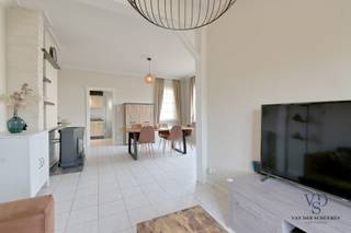 Deze instapklare woning biedt comfort en functionaliteit.<br />Via de voordeur komt u binnen in de inkomhal, die enerzijds toegang geeft tot de leefruimte en anderzijds tot de praktische kelder. Het gelijkvloers omvat verder een keuken, badkamer, apart toilet en veranda. <br /><br />Op de eerste verdieping bevinden zich een ruime slaapkamer met ingebouwde kast en een tweede kamer die kan dienen als slaapkamer, hobbykamer of bureau. De geïsoleerde zolder is bereikbaar via een zolderluik en geniet van natuurlijk licht.<br /><br />De woning beschikt over een ruime garage met carport en voldoende parkeermogelijkheden op de oprit, toegankelijk via de geautomatiseerde poort. Achter de garage bevindt zich nog een groenzone.<br /><br />O.a.: <br />- Geen renovatieverplichting <br />- Conforme elektrische keuring.