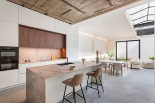 <p>Uiterst gunstig gelegen loft van ca 229 m² in de Begijnenstraat. Een heerlijke locatie, tussen het Zuid en het al even hippe Mechelseplein met de aanpalende Theaterbuurt. Deze centrale ligging staat garant voor een vlotte bereikbaarheid.<br /><br />In deze recente, kleinschalige realisatie bevindt zich dit unieke loftappartement op de gelijkvloerse verdieping in een achterbouw. De loft werd hoogwaardig afgewerkt met kwalitatieve materialen en biedt een unieke combinatie van ruimte, licht en comfort.<br /><br />De loft beschikt over een volledig geïnstalleerde open keuken met beige Emperador marmer werkblad en hoogwaardige toestellen van Miele ingewerkt: inductie kookvuur, combi-stoomoven, combi-microgolfoven, koelkast en vaatwasser. De winecooler is de kers op de taart. De royale leefruimte op strakke betonvloer, grote raampartijen en lichtstraat vormt het hart van de woning en baadt de hele dag in het licht. De zalige en uiterst rustige tuin van ca 73 m² met uitstekende privacy maakt het plaatje volledig af.<br /><br />Verder omvat het appartement een royale masterbedroom met ensuite badkamer. Luxe op en top dankzij de afwerking met vrijstaand ligbad, zeer ruime inloopdouche, dubbele lavabo en toilet. <br />De tweede slaapkamer beschikt eveneens over een ensuite badkamer met inloopdouche en lavabo. <br /><br />De vide met lager gelegen gedeelte zorgt voor een speelse indeling en kan ideaal gebruikt worden als bureauruimte of extra lounge. <br />Hier is eveneens een aparte berging voorzien met aansluiting voor wasmachine en droogkast.<br /><br />De zeer ruime inkomhal biedt de mogelijkheid om vestiaire te voorzien. Apart gastentoilet.<br /><br />Gemeenschappelijke fietsenstalling aanwezig.<br /><br />EPB in opmaak.</p>