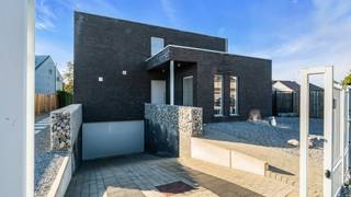 <p><strong>Stijlvol wonen met een vleugje vakantiegevoel</strong></p>
<p><strong>Ontdek deze verrassend ruime villa uit 2009, waar hedendaags wooncomfort, een doordachte indeling en een heerlijke buitenbeleving mooi samenkomen.</strong> Met ca. <strong>240 m² bewoonbare oppervlakte</strong>, vijf slaapkamers, een ruime kelder en een volledig omheind perceel van <strong>7a 62ca</strong> biedt deze woning alle ruimte voor comfortabel gezinswonen. Absolute blikvanger is de tuin met verwarmd zwembad en poolhouse: een plek waar vakantiegevoel gewoon bij het dagelijkse leven hoort.</p>
<p>Bij binnenkomst kom je terecht in een verzorgde inkomhal met gastentoilet en vestiaire. Op het gelijkvloers bevinden zich meteen twee ruime kamers die flexibel kunnen worden ingericht als slaapkamer, bureau, speel- of hobbyruimte. Daarnaast is hier een extra badkamer met douche en lavabo aanwezig.</p>
<p>Verder opent de woning zich naar een bijzonder aangename en lichtrijke leefruimte. De <strong>ruime leefkeuken en eetkamer met grijze tegelvloer</strong> vormen samen een open geheel. De witte hoogglanskeuken biedt veel opbergruimte en hedendaags comfort, terwijl de grote raampartijen en schuiframen zorgen voor een mooie verbinding met de tuin.</p>
<p>Een subtiel niveauverschil brengt je naar het salon, waar de parketvloer voor een warmere uitstraling zorgt. Ook hier geniet je van veel natuurlijk licht en creëert de elektrische haard extra sfeer. Inbouwkasten, spots en sfeerverlichting maken het geheel compleet.</p>
<p>Via de verlichte trap bereik je de verdieping. De nachthal geniet van veel natuurlijk daglicht en geeft toegang tot <strong>drie ruime slaapkamers</strong>. De royale badkamer beschikt over een dubbele wastafel, toilet en jacuzzi-bad en sluit aan op een praktische extra berging/dressing.</p>
<p>Ook buiten komt deze woning bijzonder sterk tot haar recht. De volledig omheinde tuin wordt omgeven door een groene haag en biedt een aangename combinatie van privacy en openheid. Het terras met zonneluifel kijkt uit over het <strong>zwembad met poolhouse</strong>. De zwembadinstallatie werd volledig vernieuwd en beschikt over een <strong>eigen warmtepomp die uitsluitend instaat voor de verwarming van het zwembad</strong>.</p>
<p>Daarnaast beschikt de woning over een <strong>ruime kelder</strong> met twee grote kelderruimtes en een inpandige autostaanplaats. Ook de technische installatie van het zwembad bevindt zich hier.</p>
<p><strong>Een complete en veelzijdige villa waar binnen- en buitenleven moeiteloos in elkaar overvloeien, met verrassend veel ruimte voor het hele gezin.</strong></p>