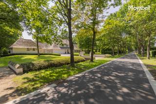 In het hart van het prestigieuze Scheutbos – een van de meest gegeerde locaties van Vlaanderen – bevindt zich deze unieke, rietgedekte villa uit 2000. Met een woonoppervlakte van maar liefst 500 m² op een riant hoekperceel van 5.529 m², biedt deze eigendom een uitzonderlijke combinatie van rust, ruimte en klasse. Deze villa in landelijke stijl ademt authenticiteit, terwijl ze moeiteloos voldoet aan de hoogste hedendaagse comfortnormen. De royale inkomhal verwelkomt u met een warme elegantie en beschikt over een vestiaire en gastentoilet. De ruime living met imposante glaspartijen baadt in natuurlijk licht en biedt een panoramisch zicht op de groene tuin. De open keuken met kookeiland vormt het kloppend hart van het huis, naadloos verbonden met een ruime eetplaats – perfect voor stijlvolle diners en gezellige familiemomenten. De woning beschikt over vijf volwaardige slaapkamers en twee smaakvol afgewerkte badkamers, waardoor zowel privacy als comfort verzekerd zijn. Een praktische wasplaats verhoogt het dagelijkse gemak, terwijl de inpandige garage ruimte biedt aan twee wagens – met bovendien extra parkeergelegenheid op het perceel zelf. Het bijgebouw biedt tal van mogelijkheden: van praktijkruimte voor vrije beroepen tot een atelier, gastenverblijf of hobbyruimte. Wilt u wonen in een oase van rust met vlotte verbindingen en alle luxe binnen handbereik? Dan is dit unieke pand in Scheutbos uw ultieme droomwoning. De woning wordt gedeeltelijk gemeubeld verhuurd. EPC 257 kWh/m2