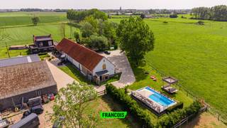 Deze uitzonderlijke eigendom, gelegen op een ruim perceel van maar liefst 7.584 m², omvat twee volledig gerenoveerde woningen: een comfortabel woonhuis en een vergunde vakantiewoning (was B&B) met een capaciteit tot 21 personen. Beide gebouwen ondergingen een grondige totaalrenovatie waarbij werkelijk alles werd vernieuwd, met bijzondere aandacht voor energiezuinigheid en hedendaags wooncomfort.<br /><br />Het woonhuis werd uitgerust met hoogrendementsbeglazing, uitgebreide isolatie (vloer, muren en dak), energiezuinige zonnepanelen en beschikt over aangename vloerverwarming die zorgt voor een optimaal wooncomfort. Daarnaast beschikt de woning over een nieuwe regenwaterput van 20.000 liter, aangevuld met een bestaande put van 10.000 liter. <br /><br />Binnenin de woning vindt u een praktische wasberging, een zonnig terras aansluitend aan de woning, en een doordachte indeling met op het gelijkvloers een slaapkamer met eigen badkamer en op de verdieping twee zeer ruime slaapkamers met een gedeelde badkamer.<br /><br />De vakantiewoning, waarvan de renovatiewerken werden opgestart in 2019, werd eveneens volledig aangepakt volgens de nieuwste normen. De imposante schuur met een lengte van 47 meter werd volledig omgevormd en geïsoleerd (vloer, wanden en dak), voorzien van hoogrendementsglas en uitgerust met zonnepanelen. <br /><br />Deze vakantiewoning beschikt over vijf ruime kamers, elk met een eigen badkamer, een zonneterras en een slaapkamer op de bovenverdieping, en is officieel vergund voor het verblijf van 21 personen. Het energieprestatiecertificaat (EPC) behaalt een uitstekende score van label A(60!).<br /><br />Verder is er een verwarmd buitenzwembad aanwezig, aangedreven door een warmtepomp, wat het geheel extra aantrekkelijk maakt voor toeristische exploitatie. De regenwatercapaciteit bij de vakantiewoning bedraagt maar liefst 40.000 liter en wordt aangevuld met een buffertank van 2.000 liter die de woning van water voorziet.<br /><br />De elektriciteit werd in beide woningen volledig vernieuwd, conform gekeurd en voldoet aan alle hedendaagse normen, inclusief de verplichte brandalarminstallatie volgens de regelgeving van Toerisme Vlaanderen.<br /><br />De centrale verwarmingsinstallatie in de vakantiewoning is bovendien uitgerust met slimme thermostatische kranen die op afstand bedienbaar zijn. Dankzij het maximale aantal toegelaten zonnepanelen, verdeeld over twee omvormers, zijn de energiekosten bijzonder laag en wordt er nagenoeg geen elektriciteit meer aangekocht.<br /><br />Tot slot beschikt het perceel nog over een vergunde loods en een open schuur, wat extra mogelijkheden biedt voor opslag, hobby’s of professionele activiteiten.<br /><br />Deze eigendom vormt een unieke opportuniteit voor wie op zoek is naar een instapklare woonst gecombineerd met een rendabele en volledig uitgeruste vakantiewoning. Voor bijkomende informatie of een bezoek kunt u steeds contact opnemen met Inti op inti@immofrancois.be of 0499 74 89 74.<br /><br />
