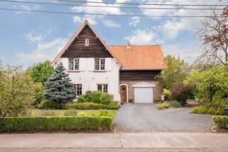 Op een zeer gunstige locatie in Onze-Lieve-Vrouw-Waver, aan de Bergstraat 16, bevindt zich deze ruime en karaktervolle woning op een perceel van maar liefst 9,6 are. De woning geniet van een uitstekende bereikbaarheid, met winkels, scholen en het centrum van Onze-Lieve-Vrouw-Waver op korte afstand. Ook de aansluiting met de R6 en omliggende gemeenten is vlot bereikbaar, waardoor deze ligging bijzonder interessant is voor wie rustig wil wonen zonder in te boeten aan bereikbaarheid.<br /><br />Bij het betreden van de woning valt meteen het authentieke karakter op. De inkomhal met houten trap vormt een mooie introductie tot de verschillende leefruimtes. Op het gelijkvloers beschikt de woning over een aparte bureauruimte, ideaal voor thuiswerk, een vrij beroep of als extra polyvalente kamer.<br /><br />De leefruimte bestaat uit een ruime en lichtrijke woonkamer die aansluit op de eetkamer. Dankzij de vele en grote raampartijen geniet de woning van bijzonder veel natuurlijke lichtinval en een aangenaam zicht op het groen rondom de woning. De verschillende leefruimtes beschikken over mooie authentieke elementen en bieden heel wat mogelijkheden om de woning verder naar eigen smaak in te richten.<br /><br />Aansluitend bevindt zich de keuken, die praktisch is ingericht en rechtstreeks aansluit op de overige leefruimtes. Zowel keuken als badkamer kunnen naar hedendaagse normen verder worden gemoderniseerd, waardoor toekomstige eigenaars de mogelijkheid krijgen om deze woning volledig naar hun eigen stijl af te werken.<br /><br />Op de verdieping bevinden zich maar liefst vijf slaapkamers, waardoor de woning bijzonder geschikt is voor een groter gezin of voor wie nood heeft aan meerdere slaap-, hobby- of werkruimtes. Daarnaast is er een badkamer met douche, wastafel en toilet.<br /><br />Ook buiten heeft deze woning heel wat te bieden. Het perceel van 9,6 are is mooi groen aangelegd en biedt zowel voor- als achteraan veel privacy en ruimte. De tuin vormt een aangename omgeving om tot rust te komen en biedt voldoende mogelijkheden voor gezinnen, tuinliefhebbers of wie graag buiten vertoeft. Aan de voorzijde is er bovendien ruime parkeergelegenheid en beschikt de woning over een inpandige garage. Buiten is er ook een bijgebouw dat ideaal is voor wie extra stockage ruimte nodig heeft of  graag zijn tuingerief stockeert. <br /><br />Kortom, een ruime woning met karakter, vijf slaapkamers, aparte bureau, garage en een mooi perceel van 9,6 are, gelegen op een bijzonder interessante locatie vlak bij het centrum, winkels en belangrijke verbindingswegen. Een eigendom met een sterke basis en heel wat mogelijkheden voor wie op zoek is naar ruimte, karakter en een uitstekende ligging.<br /><br />Voor interactieve grondplannen met foto’s, ga naar www.wijns.be en klik op de knop “virtueel bezoek”.<br />Info &amp; afspraak:  ☎ 0473/33 33 10   ✉ geoffry@wijns.be