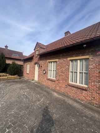 Deze uitzonderlijk charmante hoeve is ideaal voor wie op zoek is naar extra ruimte, zoals bergingen, garages en magazijnen.<br />Indeling: inkomhal met plaats voor vestiaire, apart toilet, bureauruimte of slaapkamer, gezellige woon- en eetkamer, badkamer met toilet en douche, ruime tweede slaapkamer, zeer ruime keuken, praktische berging voor stockage en een bijzonder ruime, sfeervolle veranda. Op het perceel bevinden zich bovendien twee ruime garages en een schuur met tal van mogelijkheden. De woning wordt omgeven door een mooie tuin. Oppervlakte 1600m². Voor meer informatie of een vrijblijvend plaatsbezoek: 0488/60.05.07.