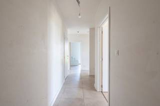 <p><strong>Wonen tussen de velden, met de stad binnen handbereik</strong></p>
<p>Sommige plekken combineren het beste van twee werelden. Het nieuwe Klokbekererf in Oud-Turnhout is zo'n plek. Deze nieuwe, doodlopende verkaveling in Oosthoven ligt op de grens van uitgestrekte velden en open landschap, terwijl het centrum van Oud-Turnhout, Turnhout en Oosthoven zich op slechts enkele minuten bevindt.</p>
<p>Hier wordt u elke dag omringd door rust, groen en ruimte. Aan de achterzijde strekt het uitzicht zich uit over de agrarische gebieden tot aan de iconische Turnova-toren in Turnhout. Aan de voorzijde kijkt u uit op een groene zone met wadi. Doorgaand verkeer is er niet, waardoor privacy, veiligheid en stilte hier vanzelfsprekend zijn. Bovendien geniet u van optimale zonoriëntaties en wordt parkeren volledig ondergronds georganiseerd.</p>
<p>Dit ruime hoekappartement in residentie "Erf" biedt een woonoppervlakte van 108,6 m² + een terras van 14,1 m². Het werd ontworpen met aandacht voor comfort, licht en leefkwaliteit. Via de inkomhal met gastentoilet en vestiaire komt u in de royale leefruimte, waar natuurlijke lichtinval langs twee zijden binnenvalt. De ruimte vormt een harmonieus geheel van zithoek, eetkamer en open leefkeuken, aangevuld met een praktische berging/wasplaats.</p>
<p>Een groot schuifraam verbindt de leefruimte met het zonnige terras. Dankzij de ideale westoriëntatie geniet u hier van lange zomeravonden met een prachtig uitzicht over de achterliggende velden.</p>
<p>Verder beschikt het appartement over 3 volwaardige slaapkamers, waarvan 1 met een eigen balkon. De badkamer krijgt aangenaam daglicht dankzij een raam en biedt plaats aan een ligbad, een inloopdouche en een dubbele wastafel.</p>
<p>De residentie is kleinschalig en omvat slechts 12 appartementen. Ondergronds heeft u de keuze uit ruime staanplaatsen of afgesloten garages, telkens met achterliggende (fietsen)berging. De lift bedient alle verdiepingen en voor bezoekers is er voldoende parkeergelegenheid binnen de verkaveling.</p>
<p>Ook op technisch vlak is dit een appartement die klaar is voor de toekomst. U koopt hier een echt BEN-appartement (Bijna Energie Neutraal), uitgerust met een individuele warmtepomp, een eigen zonnepaneleninstallatie van 2.000 Wp, vloerverwarming, ventilatie C en een doorgedreven isolatie met onder meer 11 cm vloerisolatie en 14 cm isolatie in de buitenmuren. Deze duurzame technieken zorgen voor een bijzonder laag energieverbruik en een hoog wooncomfort.</p>
<p><strong>De prijs van het appartement bedraagt 307.482 euro, exclusief aankoopkosten (btw en registratierechten) en staanplaats. Staanplaatsen met eigen berging of afgesloten garages zijn beschikbaar vanaf 27.000 euro, exclusief aankoopkosten. </strong>Voor dit volledig afgewerkte appartement, inclusief staanplaats met berging en alle aankoopkosten (btw, registratierechten, notariskosten, aktekosten en aansluitingen van de nutsvoorzieningen), bedraagt de totale investering ongeveer 404.000 euro.</p>
<p>Bent u op zoek naar een energiezuinig appartement op een unieke locatie waar rust, ruimte en bereikbaarheid samenkomen? Dan maken wij graag tijd vrij om u het project ter plaatse te laten ontdekken. In de nabijgelegen residentie "Klok" kunnen we nog enkele appartementen op andere verdiepingen aanbieden.</p>