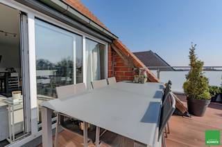 Splendide appartement penthouse avec 2 chambres et grande terrasse orientée plein sud au marché des légumes.<br /><br /><u>Composition:</u><br /><br />Entrée avec vestiaire et toilettes séparées.<br />Séjour avec coin salon et salle à manger.<br />Grande terrasse exposée sud en toute intimité.<br />Cuisine entièrement équipée.<br /><br />Chambre avec lit double avec placards.<br />Salle de bains douche à l'italienne, lavabo et connexion pour lave-linge.<br />Deuxième chambre avec coin bureau et place pour un lit superposé.<br /><br />Local à vélos commun facile dans la résidence.<br /><br />Planifiez dès maintenant votre visite sur place via 050 62 11 20 ou info@agenceschmitz.be.<br /> 