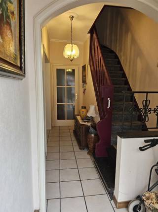 Rustig gelegen, te renoveren rijwoning op een perceel van 128 m². Indeling: Inkomhal, ruime living, aparte ingerichte keuken (vernieuwd), berging en apart toilet, tweede berging en kelder. Verdieping: 2 grote en 1 kleine kamer. Zolderluik naar de ruime zolder (dak in goede staat maar niet geïsoleerd). Recente nieuwe ramen, gaskachel in de living, Zonnig stadstuintje.