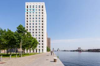 <p>Het oudste havengebied van Antwerpen, ’t Eilandje, heeft doorheen het ganse jaar zowel een vakantie als thuisgevoel. Door water omgeven en toch op 5 minuten in het centrum van ’t Stad. Wat wil je nog meer? <br /><br />Op de 14de verdieping van residentie “Westkaai 71” bevindt zich dit recent appartement van ca. 82 m², waar sereniteit en comfort harmonieus samenkomen. Dankzij de doordachte indeling en de grote raampartijen geniet het appartement van een aangename lichtinval en een ruimtelijk gevoel. Doorheen het volledige appartement werd gekozen voor een hoogwaardige parketvloer, wat zorgt voor een warme en stijlvolle uitstraling.</p>
<p>Wanneer we in de leefruimte terechtkomen zal u omvergeblazen worden van de magnifieke zichten over de Scheldebocht en de stad Antwerpen. Unieke zichten over unieke locaties, vanop het terras welke toegankelijk is vanuit de leefruimte.<br /><br />De op maat gemaakte keuken is geïnstalleerd met kwalitatieve toestellen en heeft een fijn contact met de leefruimte. Hiernaast vinden we een handige berging terug welke voorzien is van aansluitingen voor een wasmachine en droogmachine.<br /><br />Twee volwaardige slaapkamers delen een moderne badkamer voorzien van een douche in bad en een dubbele wastafel met opbergkasten.<br /><br />Een praktische kelderberging is inbegrepen in de prijs en biedt extra opbergruimte. Daarnaast bestaat de mogelijkheid om drie ondergrondse parkeerplaatsen aan te kopen aan € 37.300/stuk.</p>
<p>Je eigen uitkijkpost over de stad Antwerpen en de Schelde?<br />Kom deze samen met ons ontdekken, contacteer LISTED: +32 3 283 51 51.</p>