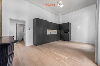 Wij stellen u graag deze exclusieve studio voor op de Bondgenotenlaan in Leuven, gelegen in een historisch gebouw met slechts 8 entiteiten. Het pand werd met veel zorg volledig gerenoveerd, met behoud van het authentieke karakter. Bij het betreden van het gebouw valt meteen de statige inkomhal op, met originele details die de klasse van het geheel onderstrepen. Het appartement bevindt zich op de eerste verdieping en voelt uitzonderlijk ruim aan dankzij plafondhoogtes van meer dan 4 meter. De grote raampartijen met balkon zorgen bovendien voor een overvloed aan natuurlijk licht. In de leefruimte springt de openhaard met groen accent meteen in het oog en draagt ze bij aan de unieke uitstraling van het appartement. Originele elementen werden harmonieus gecombineerd met een hedendaagse, hoogwaardige afwerking, wat resulteert in een bijzondere woonbeleving. De keuken is volledig uitgerust en biedt alle modern comfort. Verder beschikt het appartement over een stijlvolle badkamer met douche, lavabo en toilet. Achteraan kan u bovendien genieten van een uitzonderlijk ruime gemeenschappelijke tuin, een zeldzame troef op deze locatie. Er is ook een mogelijkheid tot huurkoop. Kortom: een buitenkans voor wie exclusief en stijlvol wil wonen of investeren op één van de meest gegeerde locaties in Leuven. Interesse? Contacteer ons via info@homies.be of 016 22 82 22.<br />