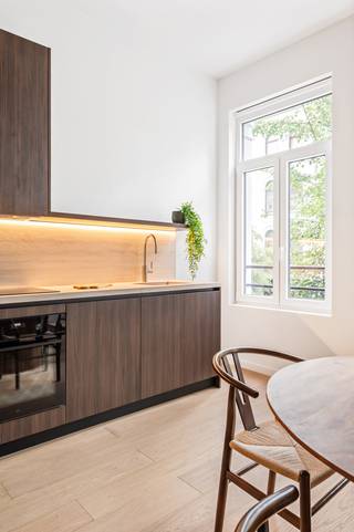 Op een absolute toplocatie in Antwerpen — vlak bij de Scheldekaaien en de bruisende sfeer van Het Zuid — bevindt zich dit prachtig gerenoveerde appartement op de eerste verdieping van een kleinschalig gebouw. Dankzij een stijlvolle afwerking met warme houten parketvloeren en strakke, eigentijdse elementen ademt het appartement een gezellige sfeer uit.<br /><br />Bij het betreden van het appartement valt vooraan meteen de gloednieuwe keuken op. Deze strakke keuken is voorzien van stijlvolle, donkere houtaccenten, ruime opbergkasten en alle moderne ingebouwde toestellen. De keuken gaat naadloos over in de gezellige leefruimte, waar grote raampartijen zorgen voor een heerlijke inval van natuurlijk daglicht. Een grote troef van deze leefruimte is de directe toegang tot het ruime, zuedgelegen terras, waar je in alle rust en privacy van de zon kunt genieten.<br /><br />Wanneer je via een subtiel trapje naar de achterzijde van het appartement wandelt, kom je in de rustige privézone terecht. Hier vind je eerst een handige, aparte berging met aansluitingen voor een wasmachine en droogkast, evenals een afzonderlijk toilet. Aansluitend bevindt zich de moderne badkamer, die hoogwaardig is afgewerkt met een ruim lavabomeubel voorzien van dubbele opbouwkommen en een royale inloopdouche met een strakke glazen wand. Helemaal achteraan liggen de twee ruime en volwaardige slaapkamers, die dankzij hun ligging aan de achterzijde optimale rust garanderen.<br /><br />Tot slot biedt het gebouw nog enkele hele praktische extra's. Zo is er op het gelijkvloers een gemeenschappelijke fietsberging aanwezig en beschik je in de kelderverdieping over een private berging voor extra opslagruimte.<br /><br />Ben jij op zoek naar klassevol en instapklaar wonen op een toplocatie in Antwerpen?<br /><br />Maak snel een afspraak voor een bezichtiging via info@goose.be of bel naar 03 369 36 38.