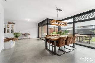 Op zoek naar een ruime, recente (bouwjaar 2022) én energiezuinige woning? Deze instapklare gezinswoning biedt maar liefst 229 m² bewoonbare oppervlakte op een perceel van 325 m² en combineert hedendaags wooncomfort met een praktische indeling.<br /><br />Bij het binnenkomen wordt u verwelkomd in een inkomhal met gastentoilet die toegang geeft tot de  lichtrijke leefruimte met grote raampartijen.<br /><br />De leefruimte gaat naadloos over in de open keuken met stijlvol keukeneiland. De keuken vormt het hart van de woning en biedt alle ruimte voor gezellige familiemomenten en etentjes met vrienden.<br /><br />Aansluitend bevindt zich een ruime wasberging/voorraadkamer, ideaal voor extra opslag en een georganiseerde huishouding.<br /><br />De woning beschikt over vier volwaardige slaapkamers, waaronder een master bedroom met eigen dressing. Daarnaast zijn er twee comfortabele badkamers, wat zorgt voor optimaal wooncomfort voor het hele gezin.<br /><br />Een absolute troef is de zeer ruime zolderverdieping met vaste trap, die tal van mogelijkheden biedt als hobbyruimte, extra opslag of toekomstige uitbreiding.<br /><br />Buiten geniet u van een aangename tuin met een deels overdekt terras, waar het heerlijk vertoeven is in elk seizoen. De woning beschikt bovendien over een carport met buitenberging en voldoende parkeergelegenheid op eigen terrein.<br /><br />Ook op technisch vlak scoort deze woning uitstekend:<br />•	Gekeurde elektrische installatie<br />•	Kwalitatieve afwerking <br />•	8 zonnepanelen<br />•	Asbestvrij<br />•	Zeer energiezuinig karakter (BEN -woning – E29 – label A)<br /><br />Kortom, een ruime en perfect onderhouden woning met alle comfort, energiezuinigheid en ruimte die een modern gezin zich kan wensen.<br /><br />