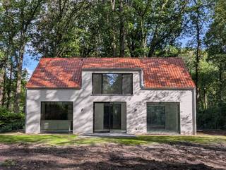 Deze stijlvolle, vrijstaande, instapklare nieuwbouwwoning van 155m² combineert hedendaags wooncomfort met een kwalitatieve afwerking. De woning bevindt zich op een perceel van 1380m², midden in het groen.<br /><br />Via de voordeur kom je in een inkomhal met gastentoilet voorzien van een douchetoilet en handenwasser. Via de smeedijzeren deur kom je in de ruime leefruimte. Grote raampartijen zorgen voor veel natuurlijk licht. De grote schuifdeur geeft uit op een terras van 12m².<br /><br />De gerieflijke keuken is o.a. voorzien van voldoende kastruimte, een kookeiland met zitmogelijkheid, twee ovens en een BORA-kookplaat met ingebouwde afzuiging. Via de doorloopdeur in de kastenwand kom je in de ruime berging/technische ruimte, waar zich eveneens de achterdeur bevindt.<br /><br />Boven vind je drie slaapkamers. De master bevat een ensuite dressing en grote raampartij die uitzicht geeft over het mooie groen van de tuin.<br /><br />De kwalitatief afgewerkte badkamer beschikt over een inloopdouche en vrijstaand bad. Je vindt boven ook nog een apart toilet.<br /><br />Technische aspecten:<br />* Vloerverwarming en koeling via lucht/water-warmtepomp<br />* Ventilatiesysteem D<br />* Aluminium ramen met 3-dubbele beglazing<br />* Regenwaterput van 7500l met recuperatiesysteem<br />* Voorziening voor laadpaal<br />* Woning reeds voorzien van LED-verlichting<br />* BEN-woning, EPB-attest in aanvraag<br />* Zonnepanelen kunnen nog voorzien worden<br /><br />Troeven op een rij:<br />* Vrijstaande nieuwbouwwoning, instapklaar <br />* Ruim perceel van 1380m²<br />* Rustige, groene ligging<br />* Ruime keuken met 2 ovens en BORA-kookplaat<br />* Master bedroom met ensuite dressing en zicht op groen<br />* Badkamer met inloopdouche en vrijstaand bad<br />* Gastentoilet met douchetoilet en handenwasser<br />* Keramische tegelvloer in travertin-look<br />* Smeedijzeren deur op plafondhoogte<br />* Ruime berging met binnen- en buitentoegang<br />* Voorziening laadpaal<br /><br /><br />Grondaandeel: €185.000 (onderhevig aan registratierechten)<br />Constructie: €400.000 (onderhevig aan BTW)<br /><br />Meer info of komen kijken?<br />0497/74.74.70 of sanderdd@gmail.com