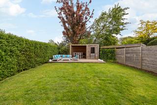 Locatie
Deze halfopen bebouwing is gelegen in Hove, langs de Mechelsesteenweg. Ondanks de centrale ligging geniet u in de woning en de tuin van een aangename rust. Dankzij de onmiddellijke nabijheid van belangrijke invalswegen en de vlotte verbinding richting Mortsel, is dit de ideale uitvalsbasis voor wie comfortabel en centraal wil wonen.
Indeling
De woning, gebouwd in 2007, beschikt over een inkomhal met gastentoilet. De lichtrijke leefruimte met eetplaats en open keuken vormt het hart van de woning en creëert een aangenaam gevoel van ruimte en verbondenheid. Via de eetkamer heeft u directe toegang tot de zonnige tuin met twee terrassen, ideaal om op elk moment van de dag van de zon te genieten. Aansluitend zorgen de praktische bijkeuken en de ruime garage voor extra comfort en bergruimte.
Op de eerste verdieping bevindt zich de ruime masterbedroom van ca. 20 m² met dressing en een badkamer uitgerust met zowel bad als douche. Daarnaast is er een tweede kamer die perfect kan dienen als slaapkamer, bureau of hobbyruimte.
De tweede verdieping biedt een ruime oppervlakte van ca. 40 m² en is momenteel ingericht als extra slaapkamer met bureauruimte. Deze verdieping beschikt bovendien over een tweede badkamer met douche.
Troeven
- Energiezuinig (EPC-label A)
- Zonnepanelen
- 3 volwaardige slaapkamers
- Ruime garage
- Zonnige tuin
- Gegeerde buurt
Technische gegevens
De woning blinkt uit in energiezuinigheid en wooncomfort. Dankzij de aanwezige zonnepanelen en de recente gasketel geniet u van een laag energieverbruik. Dit vertaalt zich in een uitstekend EPC-label A, wat een sterke meerwaarde biedt naar de toekomst toe. Bovendien is de elektriciteit volledig conform.