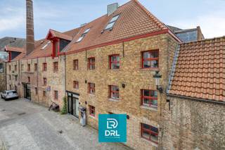 <strong>Uitzonderlijke loft van 232 m² op historische brouwerijsite in hartje Brugge</strong><br />Op een verborgen en bijzonder karaktervolle locatie in het historische centrum van Brugge bevindt zich deze exclusieve loft van maar liefst 232 m², gelegen op de voormalige site van brouwerij 't Hamerken. Een zeldzame eigendom waar industrieel erfgoed, architecturale authenticiteit en hedendaags wooncomfort elkaar perfect ontmoeten.<br /><br />De loft werd de afgelopen jaren grondig gerenoveerd met respect voor haar unieke karakter. Authentieke staalstructuren, zichtbare betongewelven, warme houtaccenten en hoogwaardige materialen zorgen voor een indrukwekkende woonbeleving. De royale open leefruimte vormt het hart van de woning en biedt een uitzonderlijk gevoel van ruimte, licht en vrijheid.<br /><br />De eigendom beschikt over twee volwaardige slaapkamers en twee stijlvolle badkamers, waardoor comfort en privacy gegarandeerd zijn. De combinatie van een warmtepomp en vloerverwarming zorgt voor een energiezuinig en aangenaam binnenklimaat gedurende het hele jaar.<br />Via de grote glaspartijen loopt de leefruimte naadloos over in een gezellig en privatief terras, een zeldzame troef midden in de Brugse binnenstad.<br /><br />Gelegen tussen het Verbrand Nieuwland en de Langestraat woont u hier op wandelafstand van de Markt, de Reien, restaurants, winkels en culturele hotspots, terwijl de rustige ligging op de voormalige brouwerijsite 't Hamerken zorgt voor maximale privacy en rust.<br /><br />Als absolute meerwaarde beschikt deze exclusieve loft over twee ondergrondse staanplaatsen (niet inbegrepen in de vraagprijs). Deze kunnen apart aangekocht worden aan 60.000 euro per staanplaats.<br /><br /><strong>Troeven</strong>
<ul>
<li><span>Exclusieve loft van 232 m² </span></li>
<li><span>Voormalige brouwerijsite 't Hamerken </span></li>
<li><span>Volledig gerenoveerd </span></li>
<li><span>2 slaapkamers </span></li>
<li><span>2 badkamers </span></li>
<li><span>Warmtepomp en vloerverwarming </span></li>
<li><span>Privatief terras </span></li>
<li><span>Authentieke industriële architectuur </span></li>
<li><span>2 ondergrondse staanplaatsen </span></li>
<li><span>Topligging in historisch Brugge</span></li>
</ul>
Meer info of een bezoek inplannen? Contacteer DRL VASTGOED, 050 65 95 95 of info@drlvastgoed.be<br />