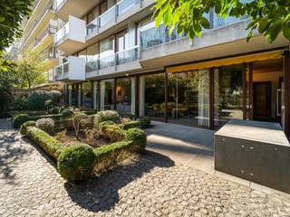 Ideaal gelegen tegenover de Jardin du Roi, in een modernistisch gebouw, gemeubileerd appartement met een bruto oppervlakte volgens EPC van ± 172 m² met drie slaapkamers en een tuin van ± 160 m² met schitterend uitzicht op de Etangs d'Elsene.<br /><br />Het appartement met twee perspectieven op de begane grond is volledig ontworpen door interieurarchitect en designer Christophe Gevers. Het geeft toegang tot een inkomhal met vestiaire en gastentoilet en leidt naar de leefruimte met open haard. Deze ruimte baadt in het licht dankzij de grote erkers met toegang tot de tuin tegenover de vijvers van Elsene. Het wordt gekenmerkt door het eikenhouten plafond en de geïntegreerde roestvrijstalen elementen en is uitgebreid met een ingerichte keuken en een wasruimte. Via de nachtgang bereikt u de hoofdslaapkamer met toegang tot de tuin, kantoorruimte, ingebouwde kleedkamer en eigen badkamer en twee andere slaapkamers met toegang tot de tuin, kleedkamer en eigen badkamer. De dienstlift biedt directe toegang tot het appartement.<br /><br />Andere: Videofoon, kelder, ingerichte wasruimte, conciërge, kosten 500 EUR inclusief verwarming, twee parkeerplaatsen optioneel (verplicht) 300 EUR. EPC: E-<br /><br />De Vijvers van Elsene en de Koningstuin vormen een groen en pittoresk decor op een steenworp afstand van het Flageyplein. <br /><br />Voor meer informatie kunt u contact opnemen met Laurence Ballaux op +32 (0) 2 640 08 01.