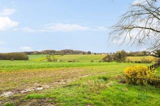Idéalement située au calme et proche du centre-ville dans un clos prisé du charmant village de Kain, cette maison 4 façades de type « plain-pied » de 130m² habitable et érigée sur un terrain de plus de 13ares se compose comme suit : <br /><br />Un hall d’entrée avec WC séparé, un beau et lumineux séjour avec feu ouvert, une cuisine équipée avec coin repas<br />, un hall desservant trois chambres à coucher ainsi qu’un bureau et une salle de douche équipée, une buanderie et un garage 1 voiture avec porte sectionnelle motorisée<br /><br />Les combles, dont l’accès se fait par un escalier escamotable sont et laissent entrevoir des possibilités d’aménagement. <br /><br />L’extérieur comprend un beau jardin arboré et idéalement orienté plein sud, dont une partie à bâtir, une terrasse et du parking pour 3 véhicules.<br /><br />TECHNIQUES : Chauffage central au mazout (Cuve enterrée de 2.500L), feu ouvert, châssis bois simple vitrage avec persiennes manuelles, boiler électrique (150L), citerne d’eau de pluie avec groupe hydrophore, fosse reliée à l’égout, RC : 1145€