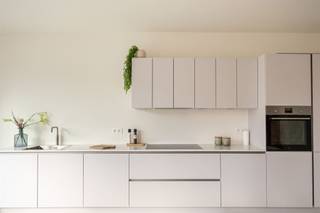 <p><span> </span></p><p><span>Droom je van een nieuwbouwwoning zonder aankoop onder btw-stelsel? Dan is dit je kans. In deze recent opgeleverde woning geniet je van alle hedendaagse comfort – warmtepomp, vloerverwarming, ventilatiesysteem, zonnepanelen en een E-peil onder 30 – waar je uitzonderlijk registratierechten op kan betalen. Gelegen in een rustige, doodlopende straat temidden het Boekenbergpark en Te Boelaerpark, woon je hier in een</span><span> </span><span>gezellige woongemeenschap en groene buurt met alle voorzieningen vlakbij. XL-staanplaats optioneel aan te kopen (€ 25.000).</span></p><p><span> </span></p><p><span>Licht, ruimte & hedendaags comfort</span></p><p><span>Van zodra je binnenkomt, valt de royale inkomhal op. De stijlvolle XL-tegelvloer loopt door over het volledige huis en zorgt voor een strak en tijdloos geheel. Er is meer dan voldoende plaats voor een vestiaire, terwijl aan de overzijde nog ruimte overblijft voor een speelhoek of een compacte thuiswerkplek. Links bevindt zich het gastentoilet met hangtoilet en lavabo.</span></p><p><span>Rechtdoor stap je de indrukwekkende leefkeuken binnen. Dankzij de hoekligging, het extra zijraam en het grote schuifraam naar de tuin baadt deze ruimte de hele dag in het natuurlijke licht. Binnen en buiten lopen hier naadloos in elkaar over. De moderne keuken is volledig uitgerust met Whirlpool-toestellen, waaronder een koelkast, diepvries met drie lades, combi-oven, vaatwasser, inductiekookplaat en een ruime spoelbak. Aansluitend bevindt zich de technische ruimte, waar alle technieken netjes zijn ondergebracht: ventilatiesysteem, aansluiting was-droogcombinatie, warmtepomp, omvormer van de zonnepanelen en de nutsvoorzieningen.</span></p><p><span> </span></p><p><span>Vier volwaardige slaapkamers en twee badkamers</span></p><p><span>Op de eerste verdieping bevindt zich de royale leefruimte aan de voorzijde van de woning. Dezelfde stijlvolle XL-tegelvloer loopt hier naadloos door en, in combinatie met de grote raampartijen, zorgt dit voor een aangename lichtinval en een heerlijk ruimtelijk gevoel. Achteraan vindt u de eerste slaapkamer: een comfortabele master bedroom met een prachtig uitzicht op de tuin dankzij de twee hoge raampartijen. De ensuite badkamer is stijlvol afgewerkt met kwalitatieve materialen en beschikt over een ruime inloopdouche, dubbel lavabomeubel met onderkasten en een grote spiegel.</span></p><p><span> </span></p><p><span>De tweede verdieping telt nog drie volwaardige slaapkamers, waardoor deze woning perfect is voor een gezin of wie extra ruimte zoekt. De nachthal baadt in het daglicht dankzij een lichtkoepel en geeft toegang tot een apart gastentoilet met handenwasser en de tweede badkamer. Net als de ensuite badkamer werd ook deze afgewerkt in dezelfde moderne, hoogwaardige stijl en uitgerust met een inloopdouche, ligbad en een dubbel lavabomeubel met onderkasten en spiegel.</span></p><p><span> </span></p><p><span>Groen wonen tussen twee parken</span></p><p><span>De ligging is een absolute meerwaarde. In deze rustige, doodlopende straat woon je tussen het Te Boelaerpark en het Boekenbergpark, met zijn bekende zwemvijver. Ideaal voor wie houdt van wandelen, lopen, fietsen of gewoon genieten van het groen. De woning maakt deel uit van een moderne woongemeenschap waar veel aandacht is besteed aan publieke ruimte en ontmoeting. Via de tuin heb je bovendien rechtstreeks toegang tot de gemeenschappelijke binnenruimte en speelzone. Winkels, scholen, supermarkten, tram, bus en een Velo-station bevinden zich vlakbij. Ook gezellige adresjes zoals Brasserie De Ekster liggen op wandelafstand, terwijl je dankzij de nabijheid van de Ring en belangrijke invalswegen snel in alle windrichtingen kan vertrekken.</span></p><p><span> </span></p>