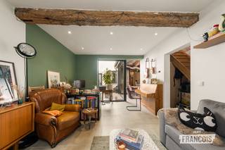 Deze charmante, witgeschilderde hoekwoning combineert authentieke Brugse gezelligheid met hedendaags wooncomfort. De woning geniet van een centrale ligging in het hart van Brugge en beschikt over een verrassend aangename stadskoer die dankzij de unieke indeling een volwaardig verlengde vormt van de leefruimte.<br /><br />Bij het binnenkomen bevindt zich een inkomhal met gastentoilet. Van hieruit komen we in de lichtrijke leefruimte met open keuken, die rechtstreeks in verbinding staat met de gezellige, omwalde stadskoer. Het grote raam kan volledig opengezet worden, waardoor binnen en buiten op een bijzonder aangename manier in elkaar overvloeien. <br /><br />Aansluitend aan de keuken bevindt zich een praktische berging/wasplaats met douche. De centrale stadskoer beschikt bovendien over een zijpoort naar de straatzijde.<br /><br />Op de eerste verdieping bevinden zich twee ruime slaapkamers, waarvan één uitgerust met maatkasten. Verder is er een volledig ingerichte badkamer met dubbele wastafel, ligbad, inloopdouche en toilet. Een afzonderlijke bureauruimte maakt het geheel compleet.<br /><br />Ook technisch beschikt de woning over een interessante basis. Zo is er centrale verwarming op aardgas, nieuw raamwerk, een conform gekeurde elektrische installatie, ventilatiesysteem D en een regenwaterput.<br /><br />Bovendien werden reeds een nieuwe voordeur en zijdeur voor de stadskoer besteld. Deze zijn inbegrepen in de verkoopprijs.<br /><br />Er dienen nog enkele afwerkingen te gebeuren, maar dit biedt tegelijk de mogelijkheid om de woning verder naar eigen smaak en wensen af te werken.<br /><br />