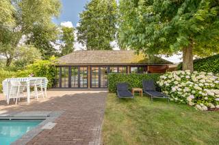 Sommige woningen moet je binnenstappen om te begrijpen. Deze is er zo één.<br /><br />Achter de met wingerd begroeide gevel van Spaans Fort 16 gaat een huis schuil dat authentieke charme moeiteloos verzoent met hedendaags comfort. Volledig gerenoveerd met oog voor detail, waarbij massieve materialen, warme haarden en kwalitatieve technieken samen één geheel vormen.<br /><br />Je komt binnen in een woning die meteen omarmt. Twee ruime, doorlopende leefruimtes liggen op een prachtige massieve eiken vloer, met tussenin een op maat gemaakte houten schuifdeur als karaktervol accent. Twee sfeerhaarden zorgen voor die onmiskenbare gezelligheid — en met in totaal vier haarden, gietijzeren radiatoren en authentieke terracotta in de eetkamer ademt elk hoekje warmte en klasse. Een groot schuifraam brengt de tuin naar binnen.<br /><br />De keuken, hoogwaardig uitgerust met onder meer een Lacanche-fornuis en natuurstenen werkblad, sluit naadloos aan op de eetkamer. Boven vind je een riante slaapkamer, een tweede slaapkamer met inloopkast, en een verzorgde badkamer met ligbad, dubbele wastafel en inloopdouche.<br /><br />Buiten wordt het pas echt genieten. Het verwarmde zwembad van circa 4 x 9,5 meter, met automatisch rolluik en recent vernieuwde technieken, vormt het kloppende hart van een klassevol aangelegde tuin met twee terrassen. Het volledig omgebouwde bijgebouw (ca 35 m2) met keuken, douche, zithoek en technische berging belooft urenlange feesten en zwoele zomeravonden.<br /><br />En het comfort zit ook in de cijfers: EPC-label B, conforme elektrische keuring, een nieuwe condensatieketel (2024) met boiler, ontkalker, 10 zonnepanelen en dakisolatie. De warmtepomp voor het zwembad werd geplaatst in 2010. De zwembadpomp werd vernieuwd in 2025 en de zandfilter in 2021. Daarnaast werd het zwembad ongeveer vier à vijf jaar geleden volledig opnieuw gepolyesterd, waardoor het technisch in perfecte staat verkeert. Parkeren doe je moeiteloos voor de deur en aan het bijgebouw.<br /><br />Authentiek wonen, vakantiegevoel het hele jaar door, op een steenworp van Antwerpen. Of je het bekijkt als een gezinswoning, luxe B&B of buitenverblijf, dit unieke huis laat zich niet samenvatten, enkel ontdekken.<br /><br />Alle attesten en plannen zijn te raadplegen op onze website bij documenten. <br /><br /><strong>Voor meer informatie (www.wellimmo.net ) of een bezichtiging mail info@wellimmo.net of tel 03 225 00 68.</strong><br /><br /><br />