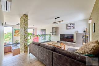 Uniek wonen in alle rust – Emmelenhoek 12A, Hamont-Achel<br /><br /><br />Deze moderne duurzame hoekwoning bevindt zich in de rustig gelegen doodlopende straat Emmelenhoek, op loopafstand van het centrum van Hamont en de Nederlandse grens. Deze woning geniet een bijzonder gunstige ligging achteraan in het recent opgeleverde project, waardoor u optimaal profiteert van privacy, rust en een ruime privatieve tuin. Bovendien betreft het een hoekwoning waarbij de tuin de hele dag door van zonlicht geniet.<br /><br />Gelegen op slechts 250 meter van de Nederlandse grens binnen 30 minuten van ASML en de High Tech Campus in Eindhoven vindt u deze prachtige woning gelegen in een rustige woonomgeving met een uitstekende bereikbaarheid en alle voorzieningen binnen handbereik. Op wandelafstand bevinden zich het stadspark van Hamont, de tennisclub, gezellige horecagelegenheden en maar liefst drie supermarkten binnen een straal van 1 kilometer. De basisschool ligt op slechts 300 meter en ook het station bevindt zich op ongeveer 1 kilometer. Bovendien heeft u op loopafstand ook een Nederlandse basisschool en Nederlandse supermarkt vanwege de ligging op de grens, terwijl u nog steeds kunt genieten van het uitgebreide fiets- en wandelnetwerk waar het groene en bosrijke Hamont-Achel om bekend staat.<br /><br /><br />Ook de woning zelf weet meteen te verrassen door haar speelse indeling, overvloedige lichtinval en hoog wooncomfort.<br /><br />U beschikt over 2 ondergrondse parkeerplaatsen, aangevuld met een private kelder en berging – een extra troef voor praktisch en comfortabel wonen.<br /><br />Bij het betreden van de woning komt u terecht in de inkomhal met gastentoilet. De woning werd ontworpen met een bijzondere niveau-indeling met split level, wat zorgt voor een uniek en open woongevoel. De open keuken bevindt zich vanwege het split level lager dan de woonkamer, waardoor deze een zeer hoog plafond heeft waarover u vanuit de leefruimte uitkijkt. Hierdoor vloeien beide leefruimtes mooi in elkaar over, terwijl ze toch elk hun eigen karakter behouden. Deze speelse architectuur van deze open split level woning creëert een bijzonder ruimtelijk effect en geeft de woning een warme, eigentijdse uitstraling.<br /><br /><br />De leefruimte geniet dankzij de hoge plafonds en grote raampartijen van een uitzonderlijke lichtinval en een aangenaam contact met buiten. Vanuit de keuken en leefruimte ervaart u overal een gevoel van openheid en comfort.<br /><br />Op de eerste verdieping bevinden zich drie volwaardige slaapkamers en een badkamer, ideaal voor gezinnen of wie extra ruimte wenst.<br /><br />Buiten wacht een ruime privatieve tuin, volledig voorzien van water- en elektriciteitsaansluitingen, zodat u deze volledig naar eigen wens kan inrichten.<br /><br />Ook op technisch en energetisch vlak blinkt deze woning uit:<br /><br />Zonnepanelen met opbrengst van circa 6.000 kWh<br />E-peil -13<br />Energielabel A+<br />Warmtepomp<br />Vloerverwarming én vloerkoeling<br />Airconditioning aanwezig<br />Zeer energiezuinig wonen met een uitzonderlijk laag verbruik<br />Deze woning combineert een rustige ligging, een verrassende architectuur, moderne technieken en uitzonderlijke energieprestaties tot een uniek geheel.<br /><br />Een instapklare en bijzonder energiezuinige woning voor wie op zoek is naar rust, comfort en een unieke woonbeleving in Hamont-Achel.<br /> 