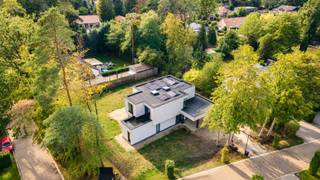 Licht, ruimte en groen lopen in deze uitzonderlijke BEN-nieuwbouwvilla haast vanzelf in elkaar over. Grote raampartijen, lange zichtlijnen en een bijzonder doordachte indeling zorgen ervoor dat de tuin vanuit vrijwel iedere leefruimte deel uitmaakt van het interieur. Gelegen in het groene Cambeenbos geniet u hier van een rustige residentiële woonomgeving, terwijl het centrum van Sint-Job, scholen en dagelijkse voorzieningen vlot bereikbaar blijven. Ook het kanaal en de omliggende natuur nodigen uit tot wandelen en fietsen, met belangrijke verbindingswegen richting Antwerpen binnen handbereik.<br /><br /><strong>Indeling</strong><br />De carport vormt architecturaal één geheel met de woning en wordt aangevuld met voldoende parkeergelegenheid op het perceel.<br /><br />Via de inkomhal met ruime vestiaire/polyvalente berging en gastentoilet ontstaat meteen een prachtig dieptezicht naar zowel de zij- als achtertuin. Dat sterke contact met buiten vormt de rode draad doorheen de volledige woning: overvloedig daglicht, open zichtlijnen en toch duidelijk afgebakende ruimtes zorgen voor een bijzonder aangename woonbeleving.<br /><br />Centraal bevindt zich de indrukwekkende, volledig op maat gemaakte leefkeuken, rechtstreeks verbonden met de eetruimte en het overdekte terras. Dankzij de elektrische lamellen kan dit terras naar wens volledig worden geopend of beschut en wordt het een natuurlijk verlengstuk van de leefruimte.<br /><br />Aansluitend aan de keuken bevinden zich een ruime berging en wasplaats met inloopdouche, gevolgd door de technische ruimte met afzonderlijke toegang langs de zijzijde van de villa.<br /><br />De eetruimte loopt natuurlijk over in de woonkamer, met daarnaast een afzonderlijke bureauruimte. Hoewel iedere ruimte een eigen functie en sfeer behoudt, staan ze voortdurend met elkaar in contact. De onderhoudsvriendelijke keramische parkettegel die over het volledige gelijkvloers werd doorgetrokken, versterkt die visuele rust en eenheid.<br /><br /><strong>Verdieping</strong><br />Op de eerste verdieping bevinden zich vier volwaardige slaapkamers. De master bedroom beschikt over een ensuite dressing en eigen badkamer, met voorzieningen voor een inloopdouche, ligbad en dubbele lavabo, deze dient men nog verder af te werken.<br /><br />Daarnaast is er een tweede badkamer met inloopdouche en dubbele lavabo, evenals een afzonderlijk toilet.<br /><br /><strong>Bijzonderheden</strong><br />Met E-peil 1 en EPC A, vloerverwarming via warmtepomp en 16 zonnepanelen werd deze villa ontworpen met een uitgesproken focus op energiezuinig en toekomstgericht wonen.<br />Verkoop onder registratierechten.