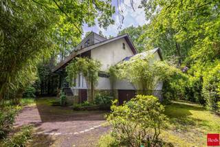 TE KOOP MET PRE-VIEW: enkel op afspraak.<br /><br />Wonen in alle rust, omringd door groen en architecturale klasse.<br /><br />In het hart van Halle, op de rand met Sint-Antonius, ligt deze unieke woning ontworpen door Renaat Braem. De woning bevindt zich in een groene omgeving en combineert natuur, licht en architectuur op een harmonieuze manier. Ze straalt het hele jaar door een uitgesproken vakantiegevoel uit.<br /><br />INDELING:<br /><br />Bij het binnenkomen betreedt u een inkomhal met gastentoilet, die toegang geeft tot de ruime leefruimte en de keuken. Beide ruimtes vloeien naadloos in elkaar over en vormen samen een warme, open leefkern. De grote raampartijen zorgen voor een connectie met de tuin en brengen de natuur letterlijk naar binnen. In de leefruimte zorgt een haard voor extra gezelligheid, terwijl de keuken praktisch is ingericht en perfect aansluit op het dagelijkse comfort.<br /><br />Aansluitend aan de keuken bevindt zich een polyvalente ruimte met zicht op de tuin. Deze ruimte wordt extra gekenmerkt door een open vide, wat zorgt voor een ruimtelijk gevoel en een mooie lichtinval.<br /><br />Op de bovenverdieping bevinden zich drie slaapkamers, een badkamer met bad en douche en een apart toilet. Ook hier geniet men vanuit de kamers van het zicht op de tuin, met bovendien toegang tot een balkon waar de rust en het groen centraal staan.<br /><br />De woning is volledig onderkelderd en biedt uitzonderlijk veel bergruimte. Daarnaast is er plaats voorzien voor het parkeren van twee wagens.<br /><br />Een unieke woning waar architectuur, natuur en wooncomfort perfect samenkomen in een oase van rust in Sint-Antonius.<br /><br />BIJZONDERHEDEN:<br />- Gunstige locatie<br />- Architecturale woning<br />- Natuurlijke materialen<br />- Veel lichtinval <br />- Midden in het groen<br />- Veel privacy<br /><br />Dit eigendom is onderhevig aan de renovatieverplichting die door de Vlaamse Regering wordt opgelegd. Meer info op https://www.vlaanderen.be/veka.<br /><br />Voor meer info of een bezoek ter plaatse kan u vrijblijvend contact opnemen met Lieselotte op 03.227.58.58 of lieselotte@reds.be.