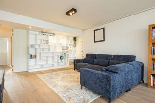 Bij het betreden van het appartement kom je terecht in een ruime inkomhal, voorzien van talrijke ingemaakte kasten die zorgen voor een overvloed aan opbergruimte. Daarnaast is er een apart gastentoilet met lavabo.<br /><br />De badkamer is uitgerust met een douche en een dubbele lavabo, eveneens met voldoende kastruimte.<br /><br />Het appartement beschikt over twee ruime slaapkamers. De eerste slaapkamer is voorzien van een ingebouwde bureauruimte en geeft toegang tot het terras, dat zich uitstrekt over de volledige breedte van het appartement aan de achterzijde. De tweede slaapkamer, de master bedroom, is bijzonder ruim en beschikt over een aansluitende, ruime dressing.<br /><br />De leefruimte met aansluitende keuken geniet van een overvloed aan natuurlijk licht dankzij de grote raampartijen. De volledig ingerichte keuken is voorzien van een kookplaat, dampkap, oven, ingebouwde vaatwasser en biedt bovendien veel opbergruimte.<br /><br />Het appartement is gelegen op de vierde verdieping, er is een lift aanwezig en een kelder. <br /><br />De gemeenschappelijke kosten bedragen 200,00 euro en is een voorschot op de verwarming, het water, de lift, elektriciteit en onderhoud van de gemeenschappelijke delen. <br /><br />In samenspraak met de verkoper kunnen de meubels overgekocht worden of het appartement zal leeg zijn bij akte. <br /><br />Een staanplaats kan aangekocht worden, deze is enkele panden verder gelegen, de kostprijs hiervan bedraagt 16000,00 euro.