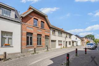 Op een absolute toplocatie in Schilde, op wandelafstand van het centrum en op een boogscheut van het gezellige kerkplein met hotspot Café Den Toren, presenteren wij deze prachtig gerenoveerde dorpswoning. Deze exclusieve eigendom combineert de authentieke charme van een karaktergevel, de hoogwaardige en uiterst smaakvolle binnenafwerking resulteren in onmiddellijk en zorgeloos genieten van alle luxe en comfort.
Bij het betreden van de woning ervaart u meteen een overweldigend gevoel van ruimte en elegantie. De riante, hoge plafonds trekken het daglicht rijkelijk naar binnen en versterken het open karakter. De verfijnde parketvloeren lopen naadloos door de leefruimtes en stralen een tijdloze warmte uit. Samen met de op maat gemaakte, stijlvolle raamdecoratie vormt dit een harmonieus geheel dat tot in de puntjes is verzorgd. In de sfeervolle zithoek geniet u tijdens koude winteravonden van de gezellige warmte van een moderne pelletkachel. De leefruimte sluit naadloos aan op een intieme, perfect ingesloten stadskoer. Deze buitenruimte is bewust compact gehouden, zodat u in alle rust, privacy en zonder onderhoud buiten kunt eten en relaxen.
Op de verdieping beschikt de woning over drie slaapkamers waarvan één ruime master bedroom, een tweede slaapkamer in gebruik als kantoor en de derde slaapkamer als combinatie dressing / logeerkamer en een moderne badkamer. Parkeercomfort in de dorpskern is bovendien gegarandeerd en inbegrepen in de vraagprijs: recht tegenover de woning bevindt zich een private ondergrondse staanplaats, ideaal voor het veilig stallen van fietsen of een compacte stadswagen. Een zeldzame opportuniteit voor wie op zoek is naar een instapklare woning met klasse en cachet in Schilde.